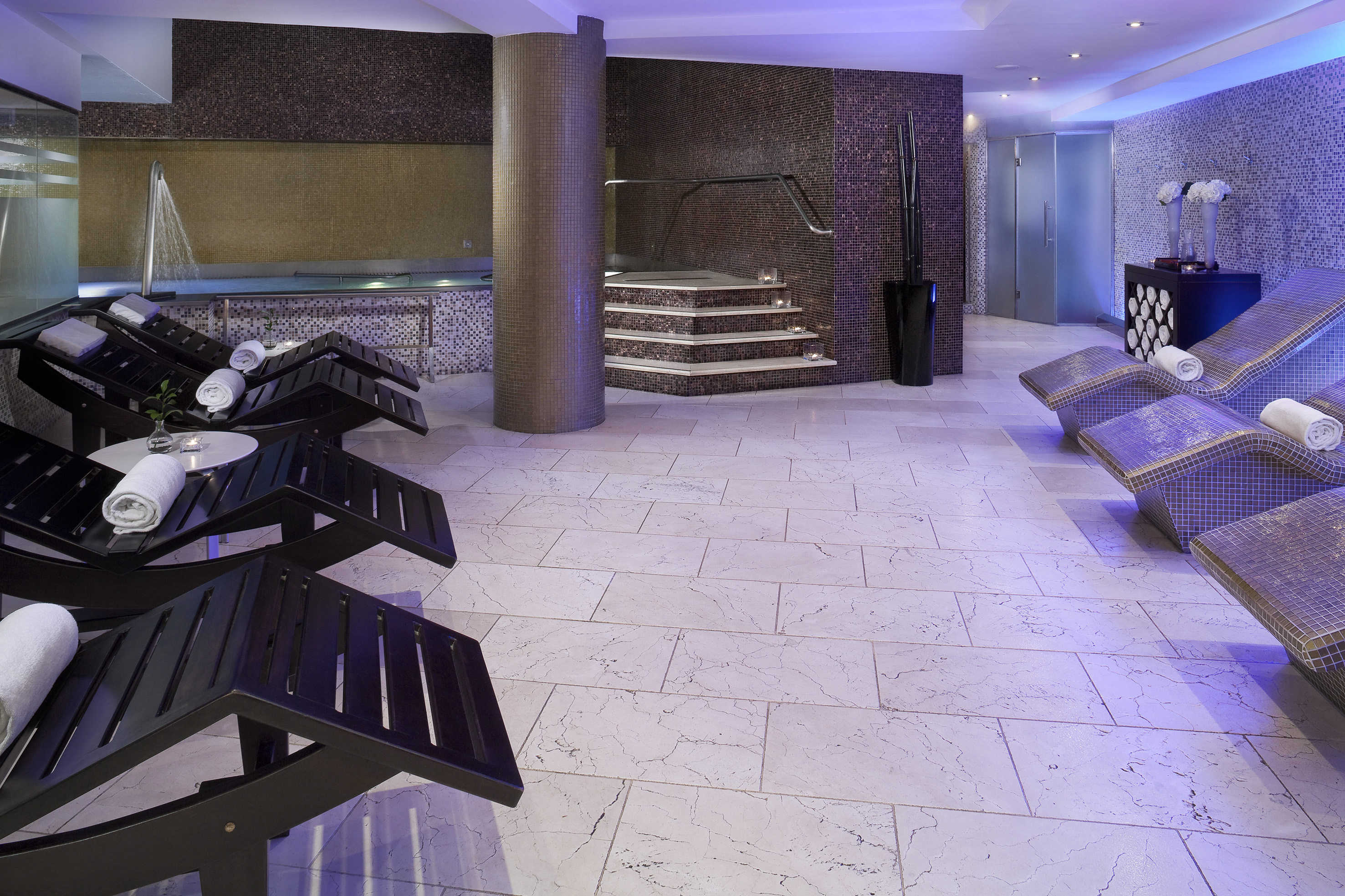 a room with a large round pool and a large staircase