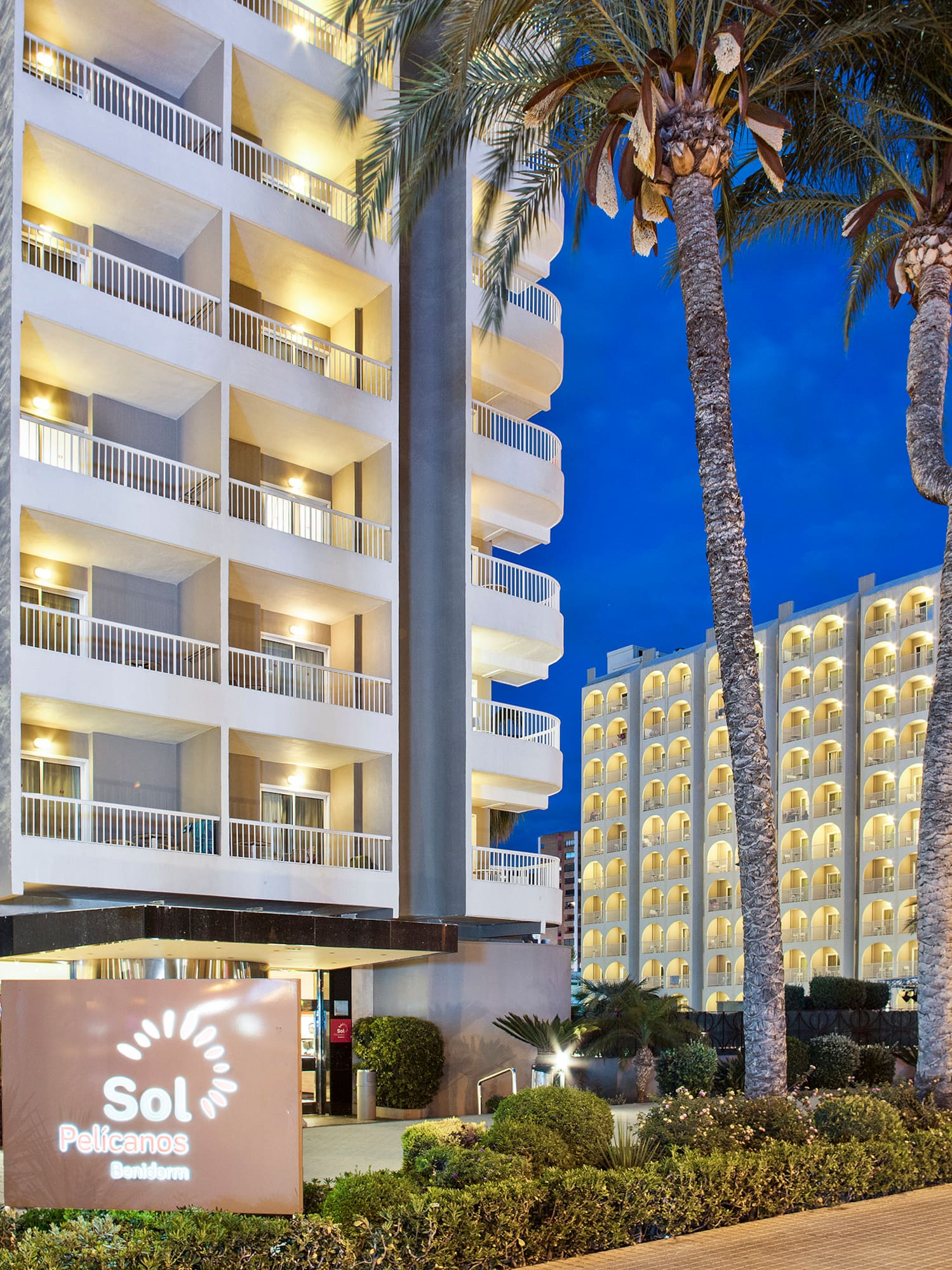 a building with palm trees and a sign