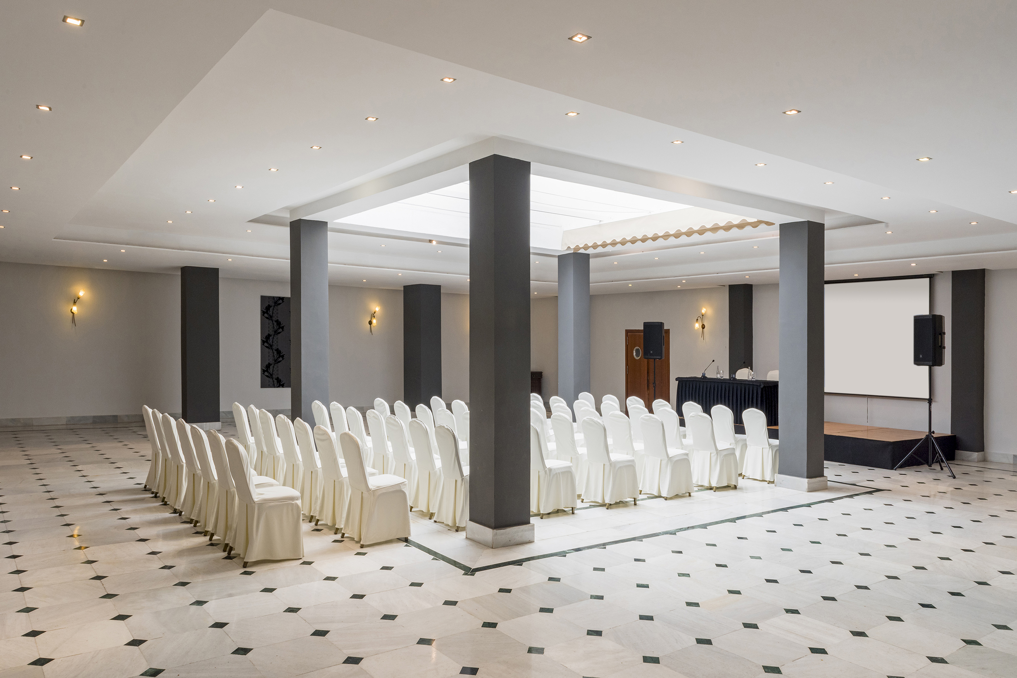 a room with white chairs and a white screen