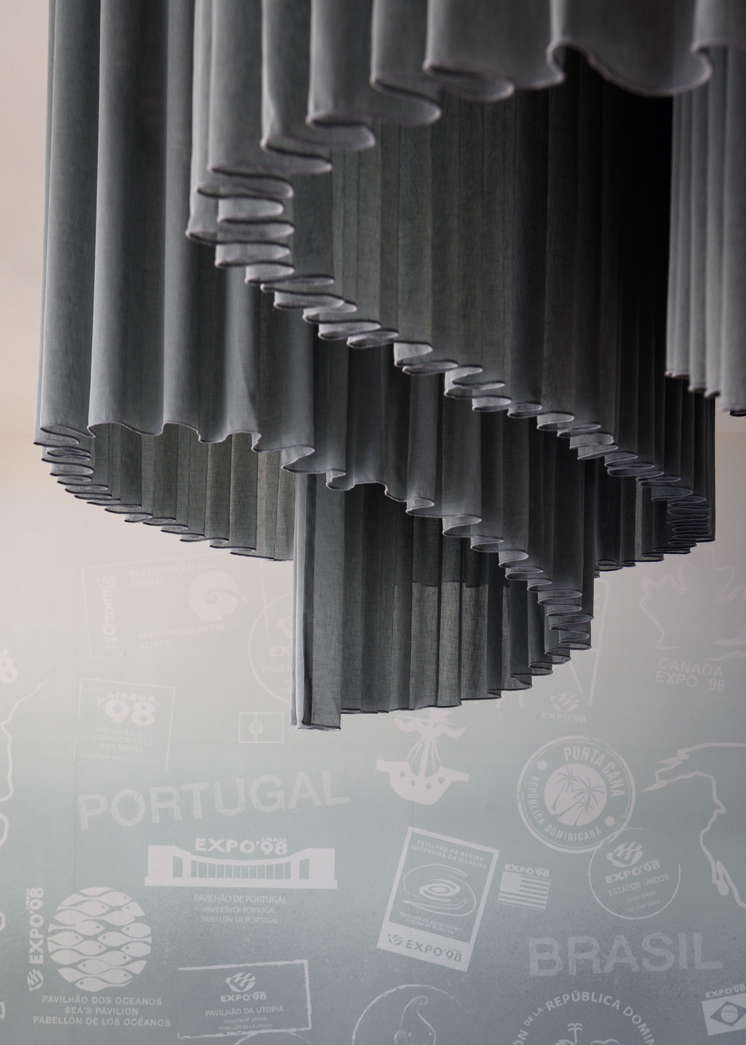 Architectural grey fabric panels creating a dynamic spiral design, Expo background.