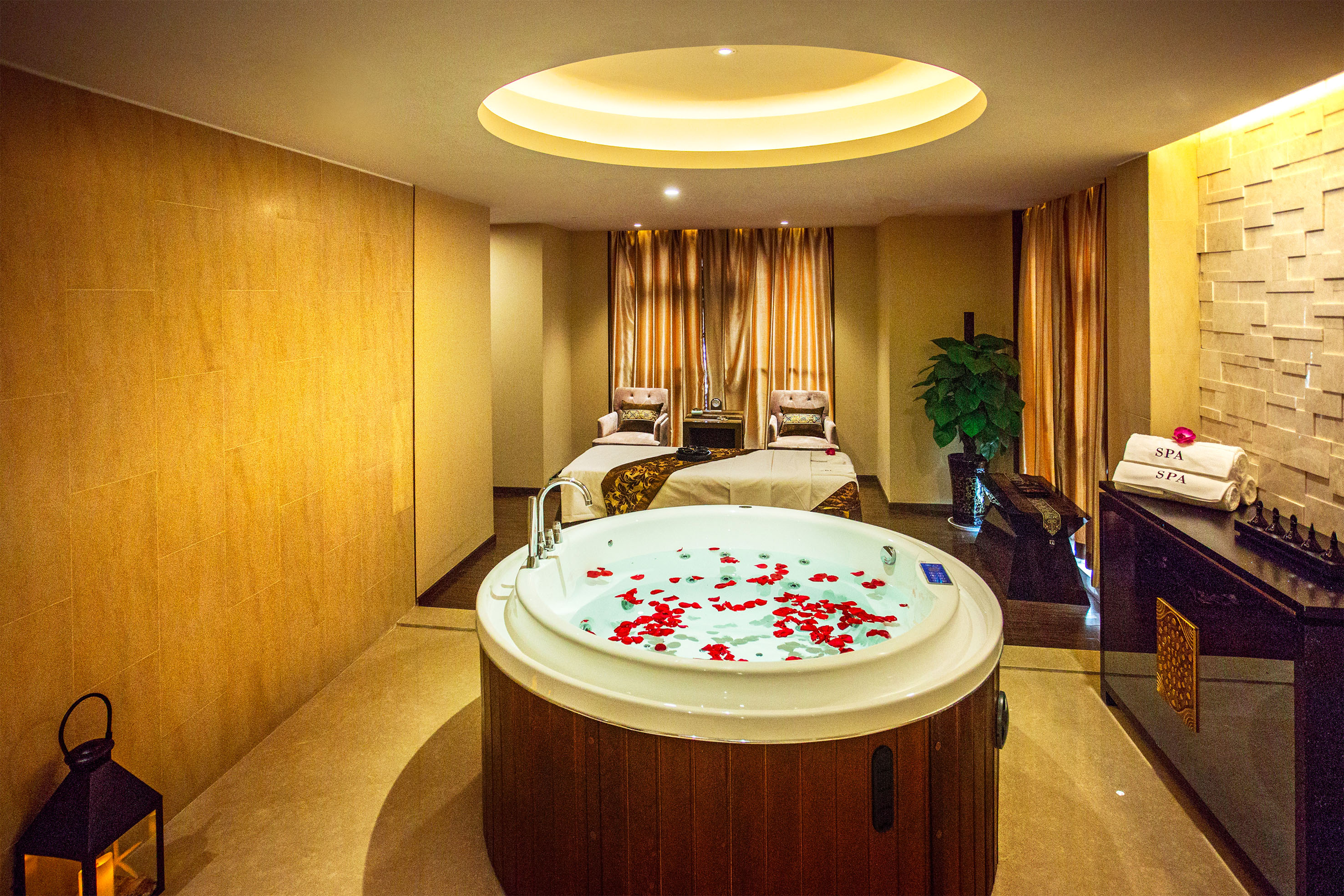 Luxury spa room with rose petal jacuzzi and two massage beds.