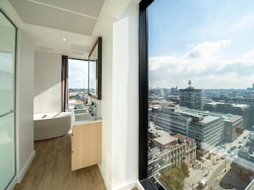 a bathroom with a large window overlooking a city