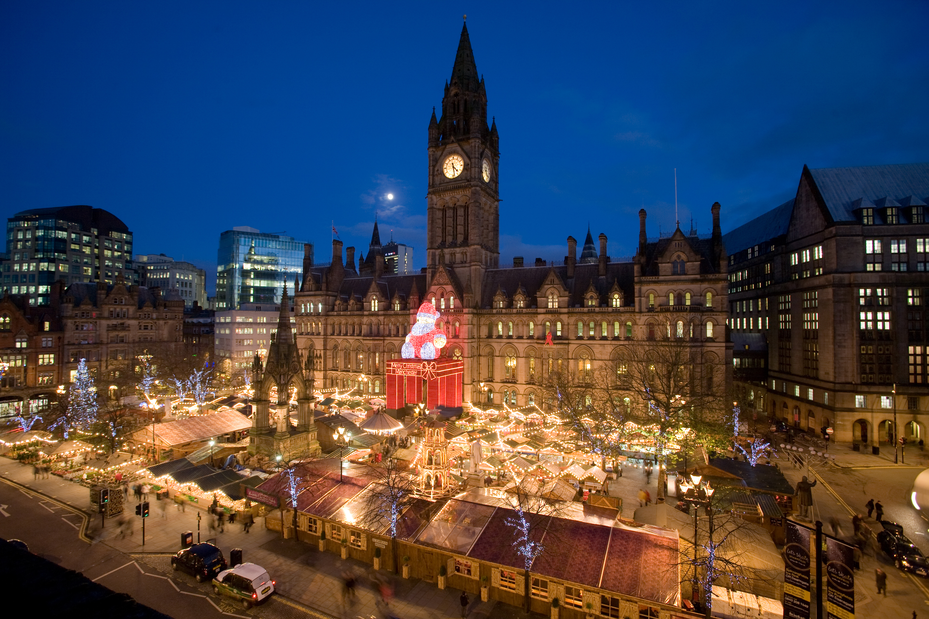 Manchester Christmas market at night, Town Hall, illuminated Santa display.