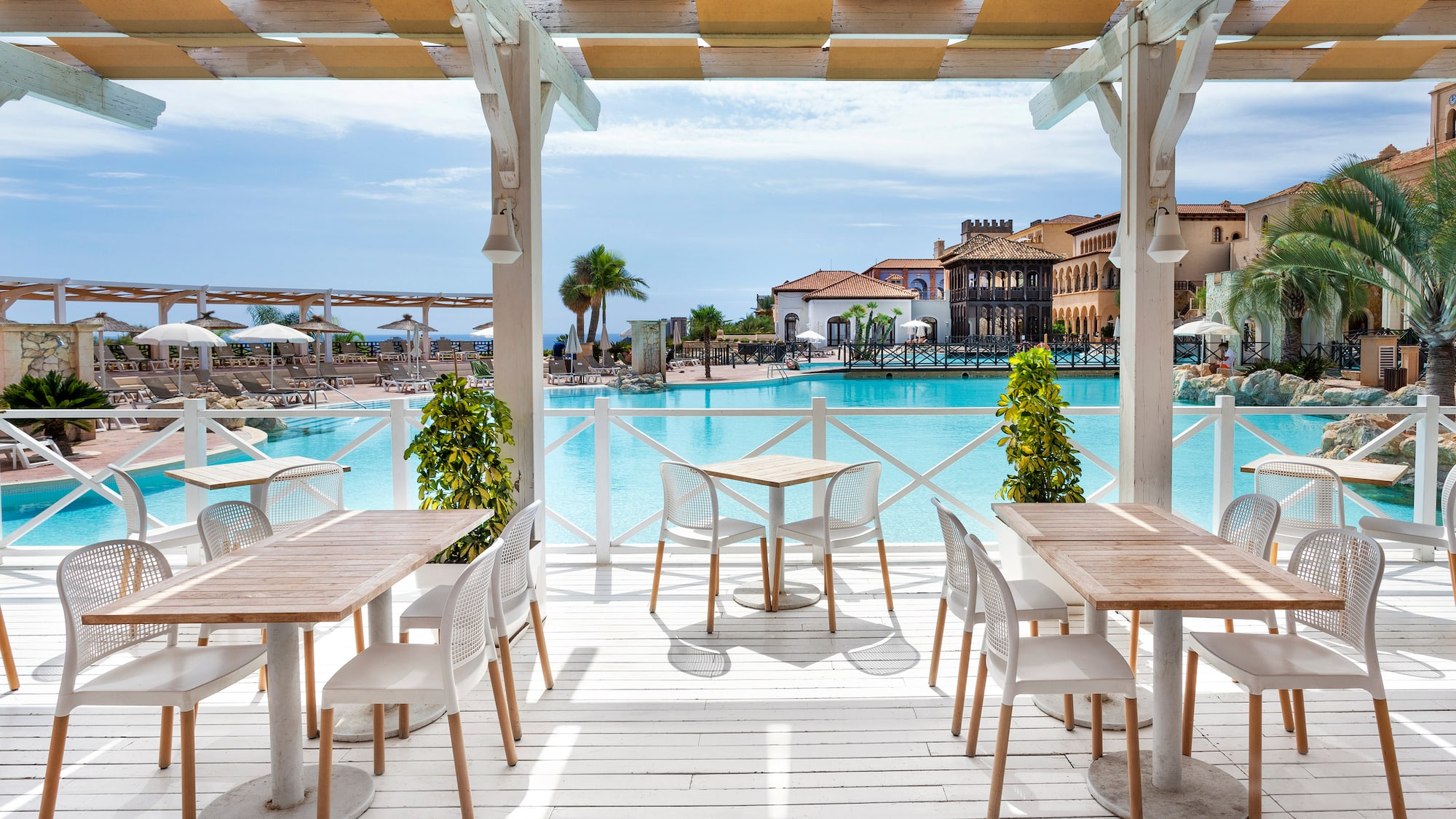 a patio with tables and chairs and a pool