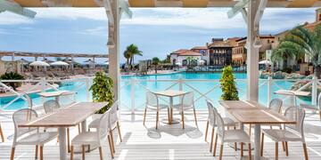 a patio with tables and chairs and a pool