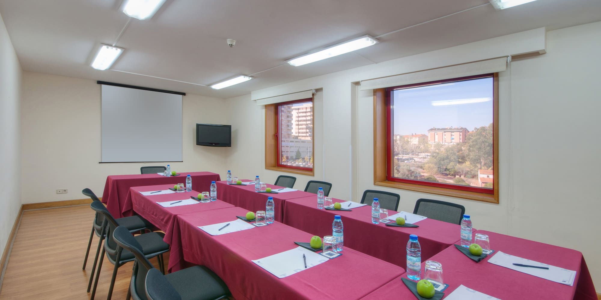 a room with tables and chairs and a projector screen