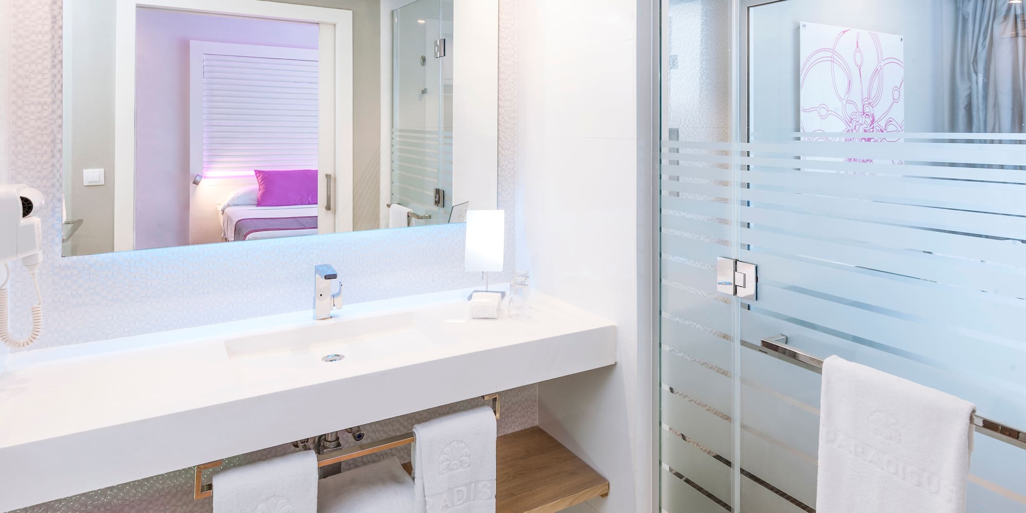 a bathroom with a glass shower door and a sink