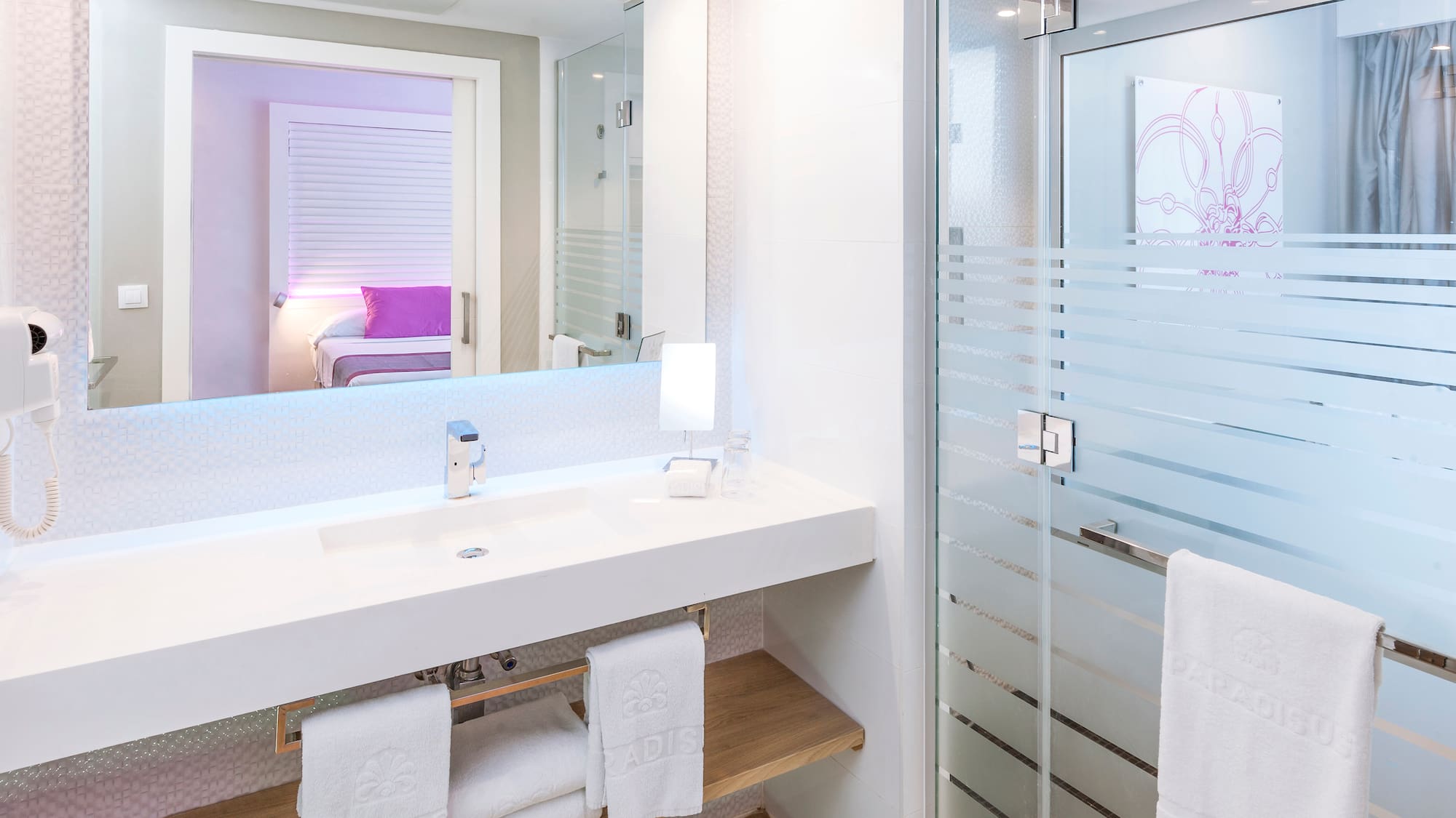 a bathroom with a glass shower door and a sink