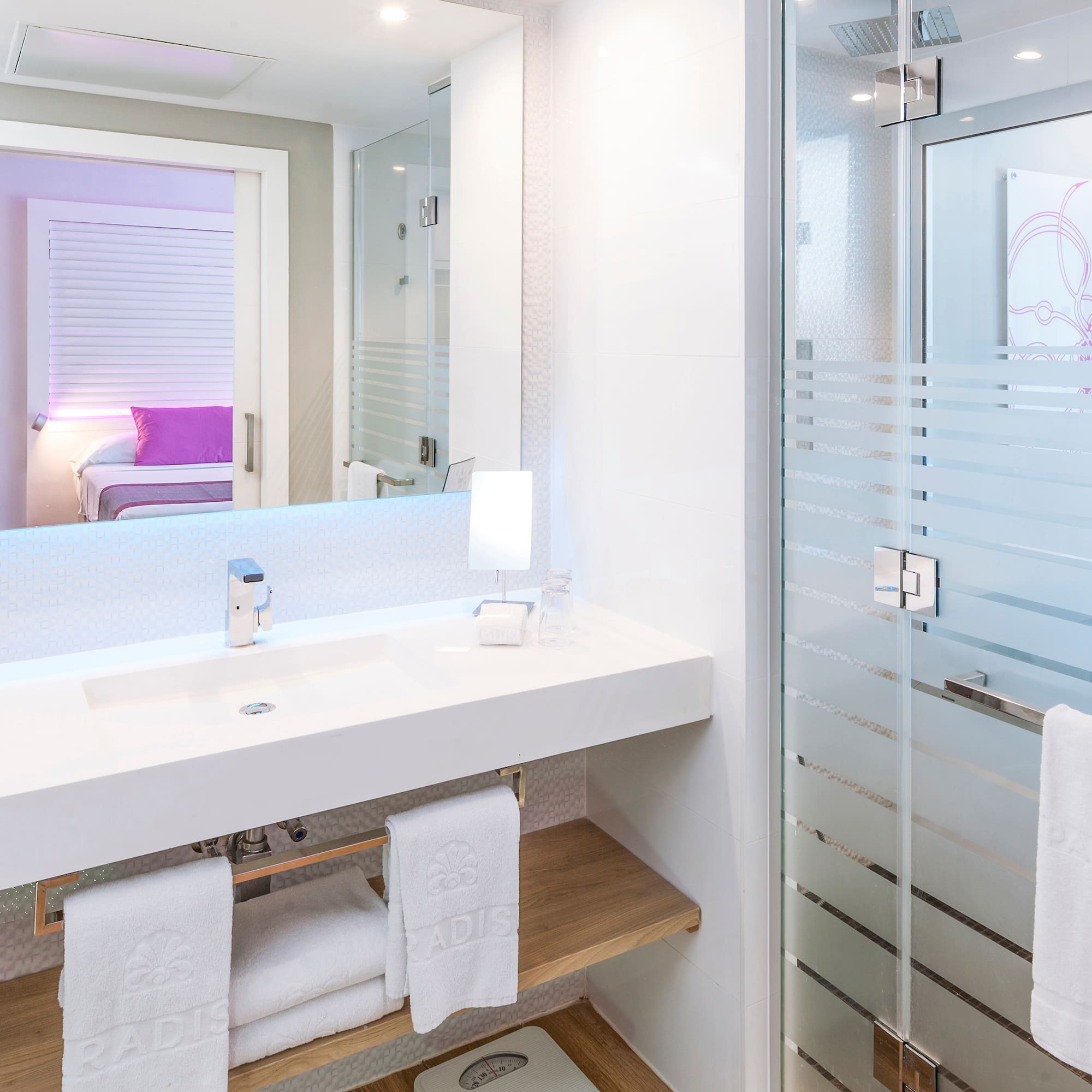 a bathroom with a glass shower door and a sink