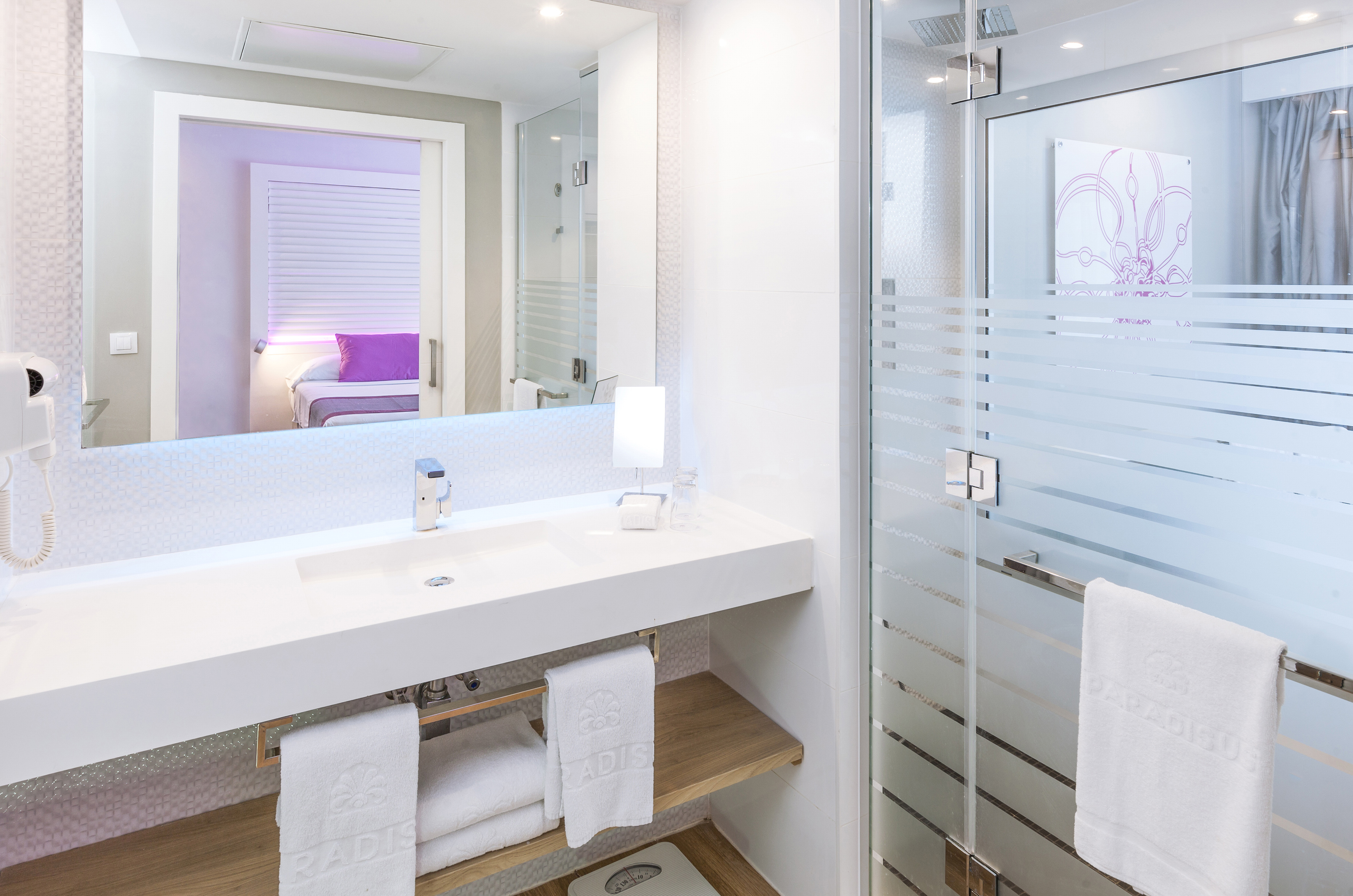 a bathroom with a glass shower door and a sink