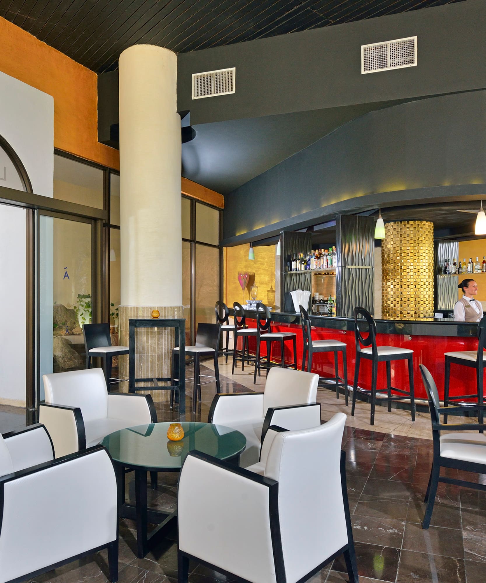 a room with a bar and a man sitting at the counter