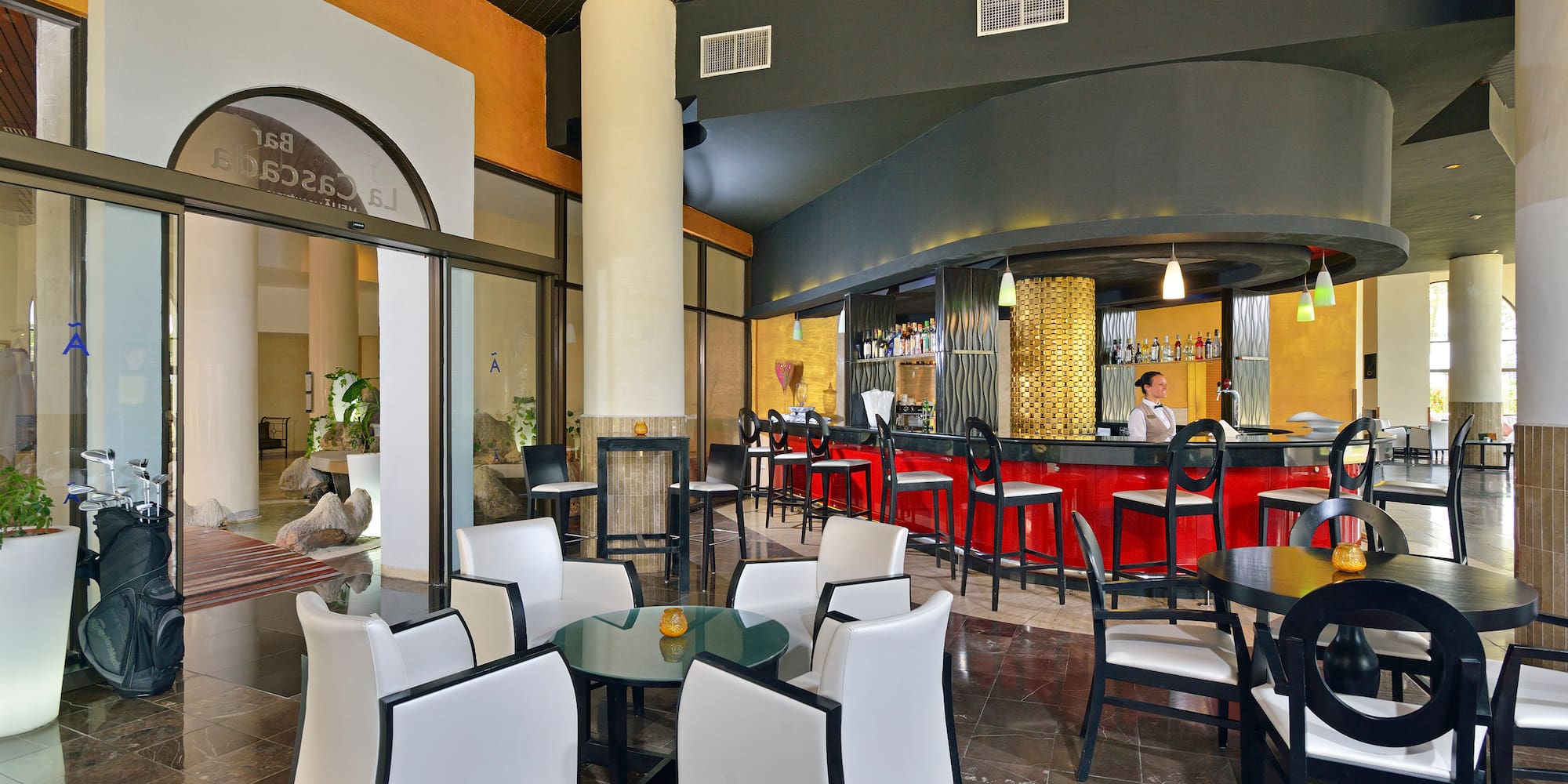 a room with a bar and a man sitting at the counter