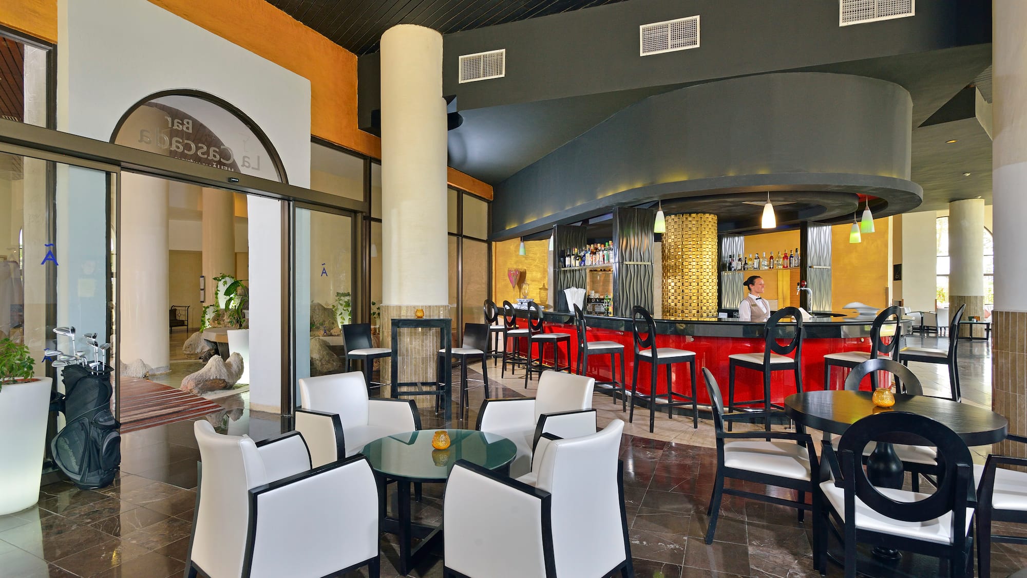 a room with a bar and a man sitting at the counter