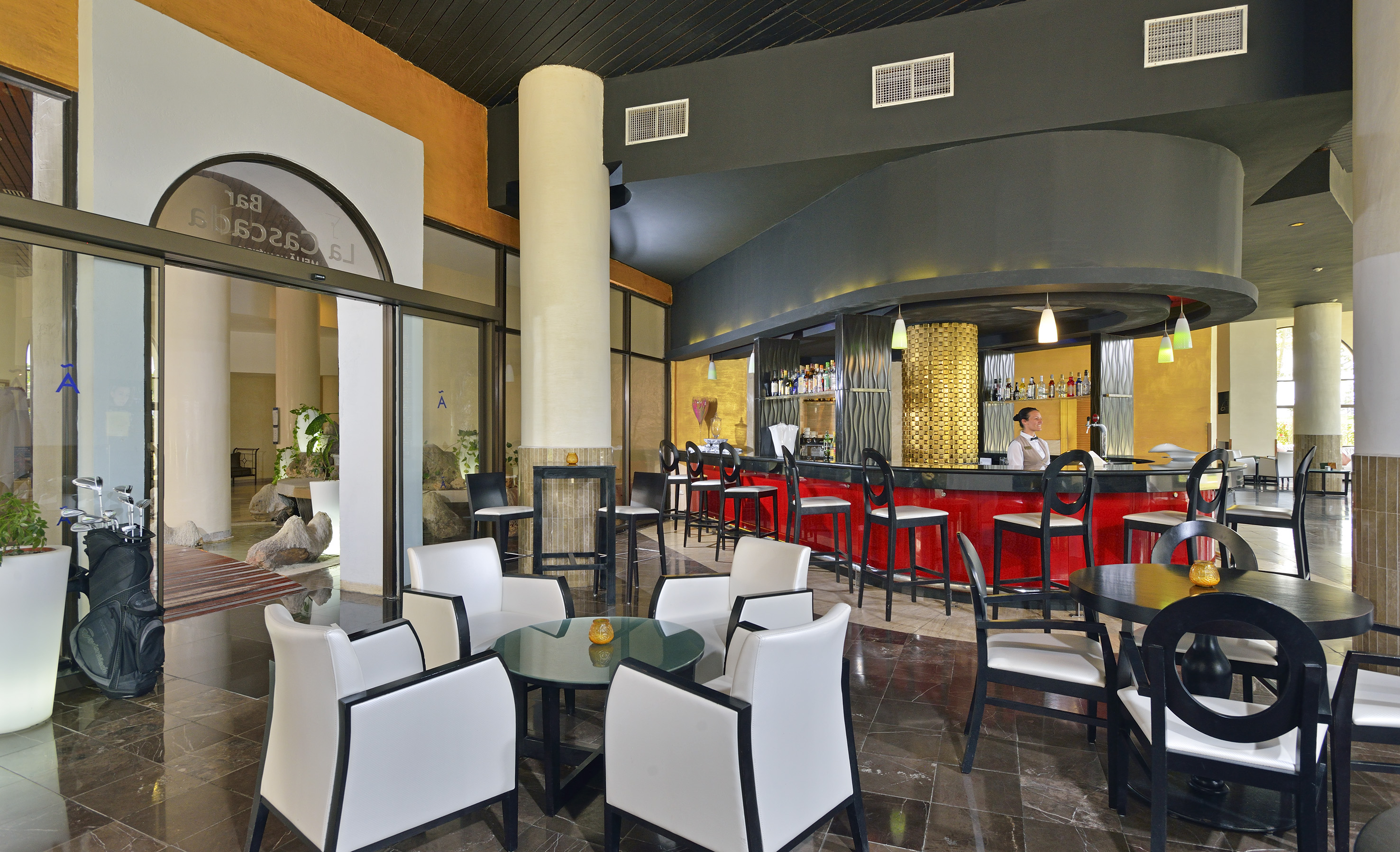 a room with a bar and a man sitting at the counter
