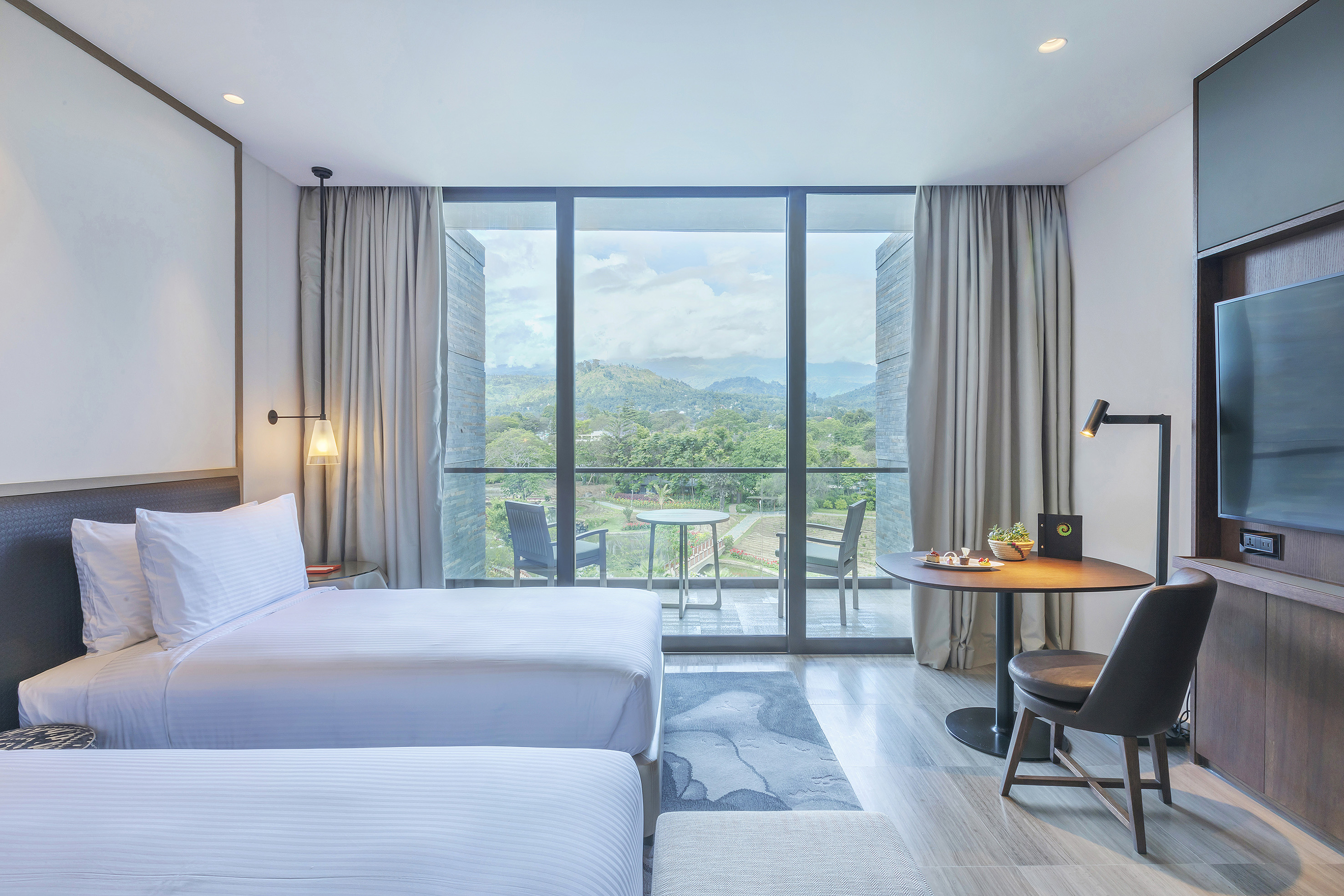 a room with two beds and a table and chairs
