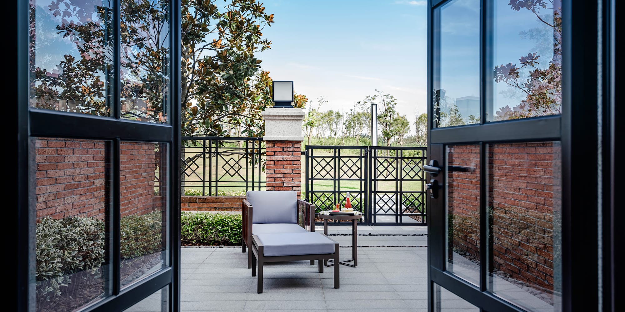 a chair and table outside with glass doors
