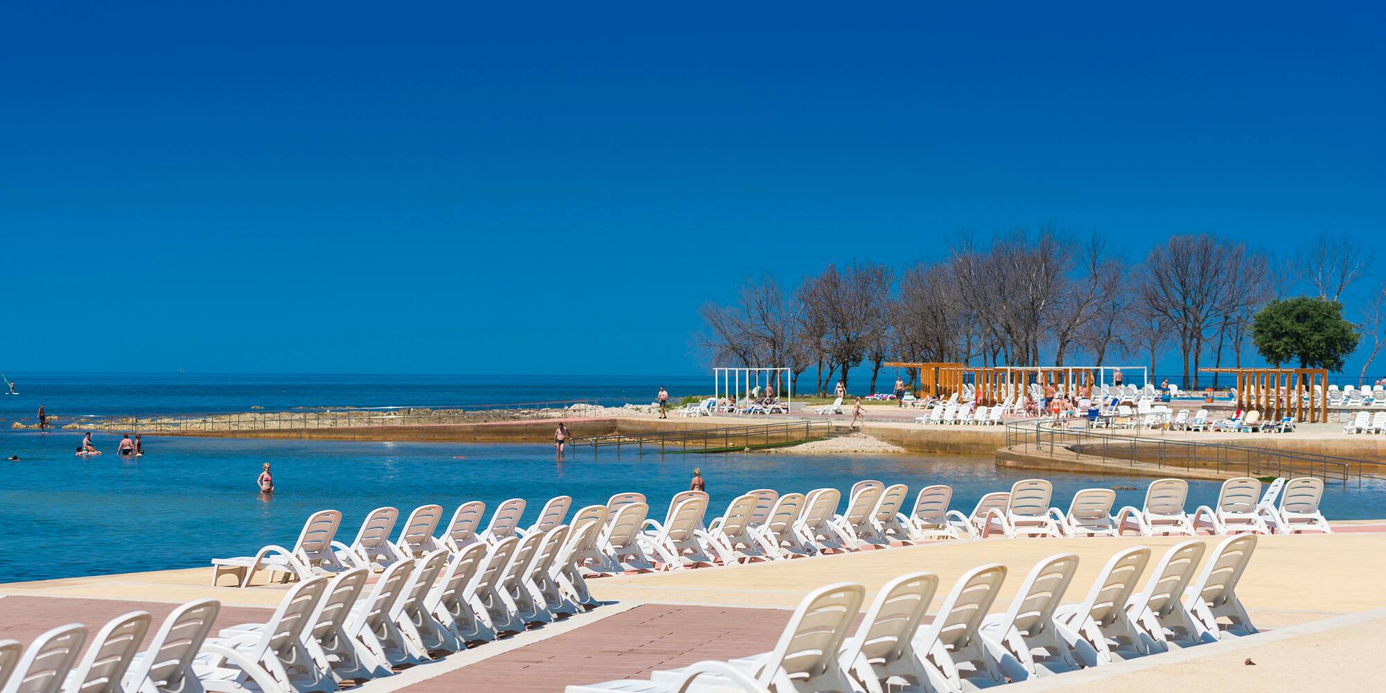 a group of white chairs on a beach