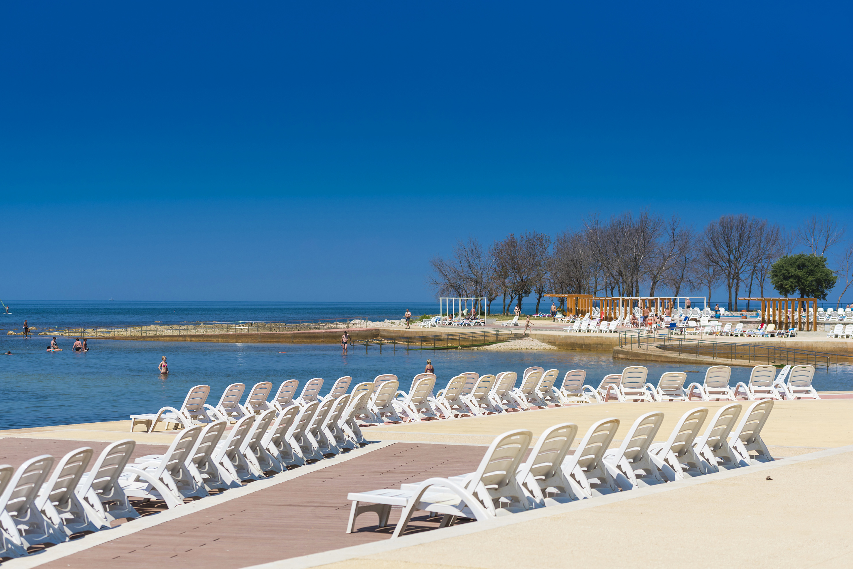 a group of white chairs on a beach