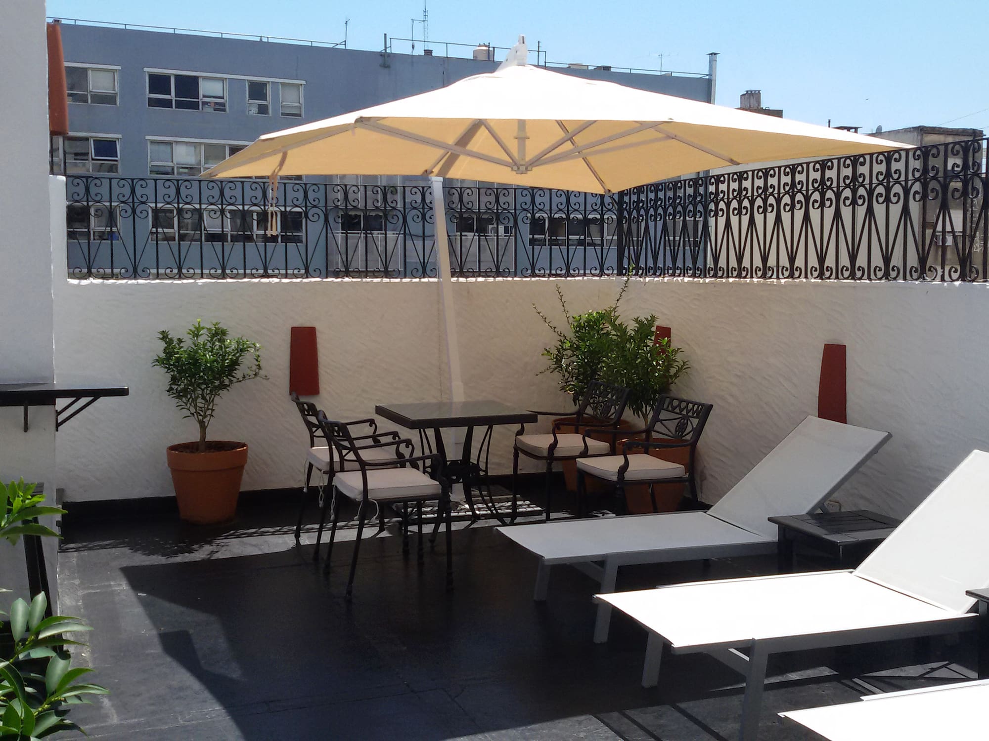 a patio with chairs and umbrella