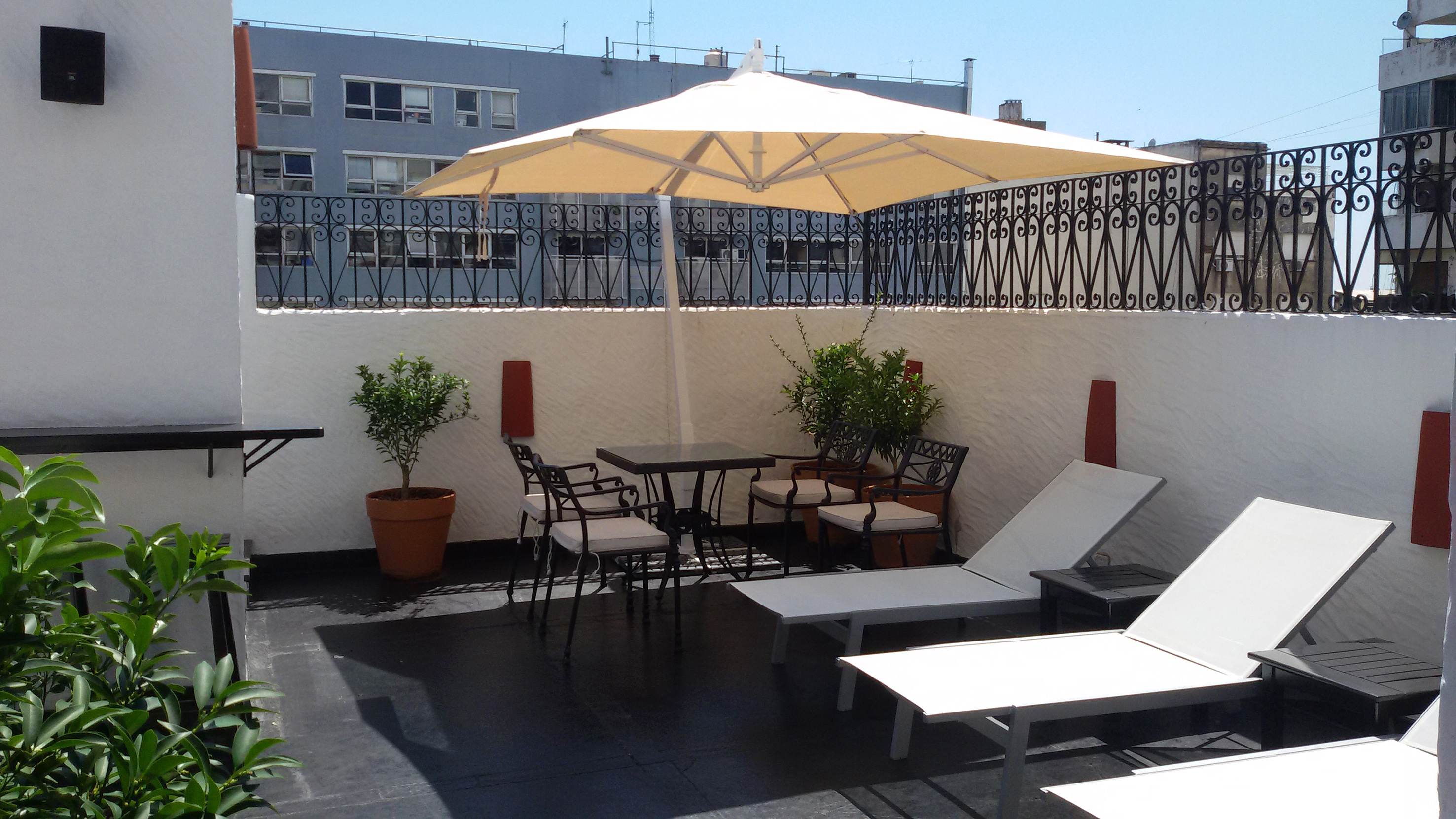 a patio with chairs and umbrella