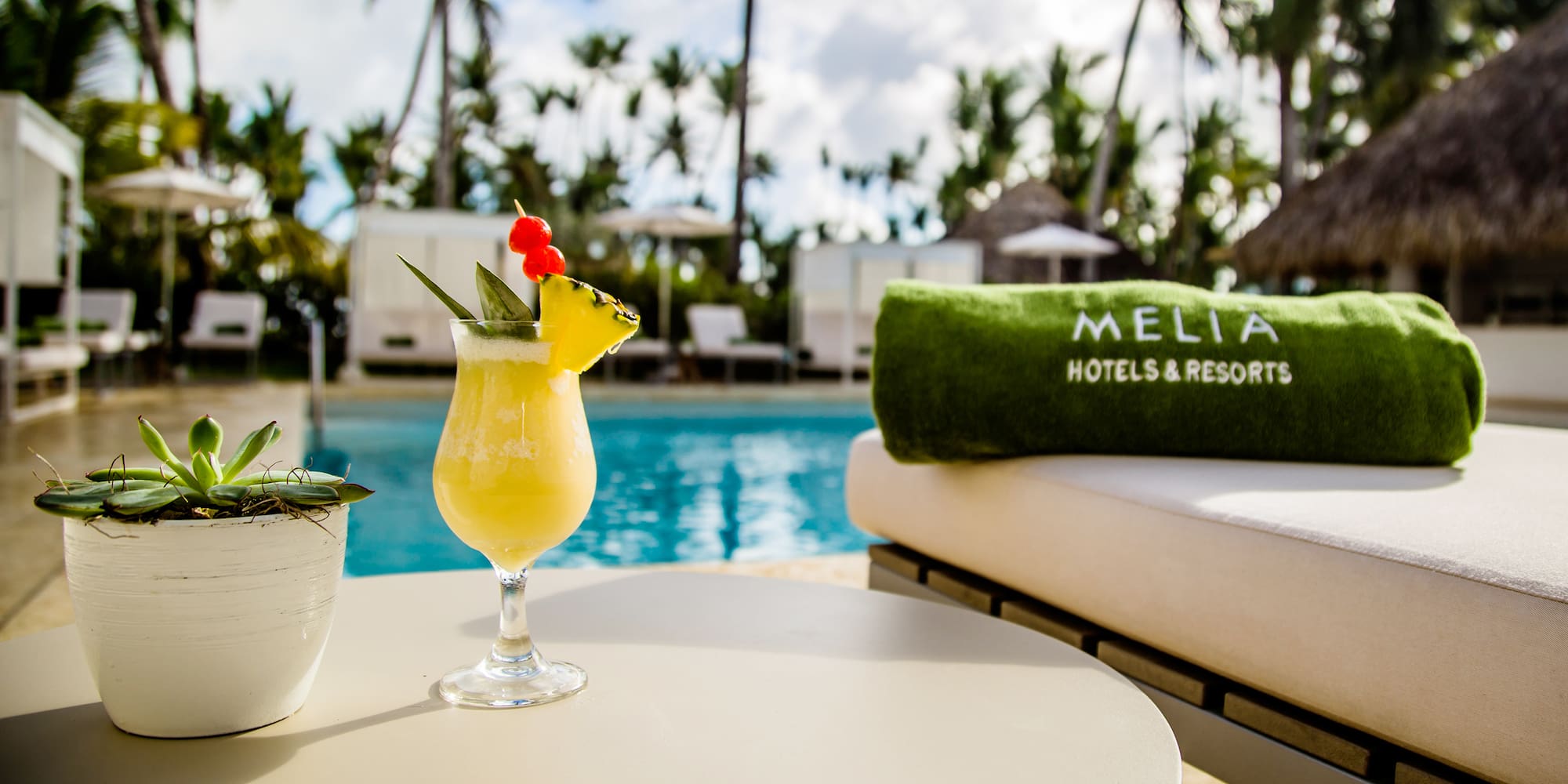a drink on a table by a pool