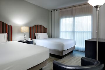 a room with two beds and a lamp