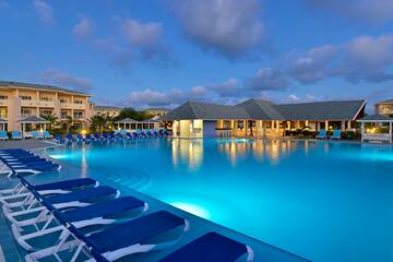 a pool with lounge chairs and a building