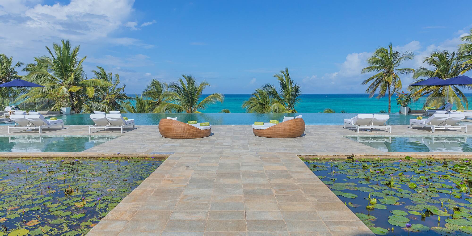a pool with lounge chairs and water in the background