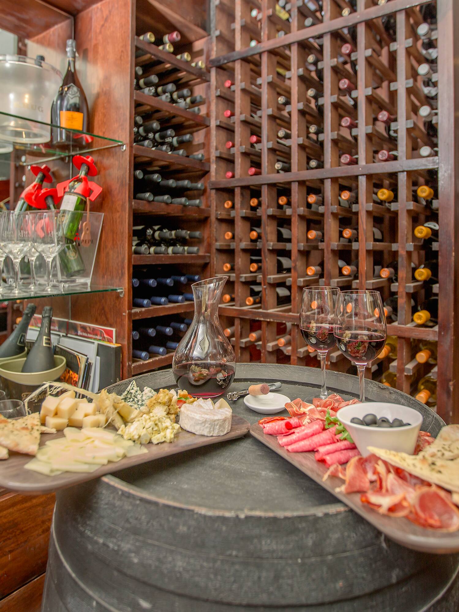 a wine rack with wine glasses and food on a table