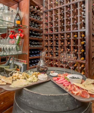 a wine rack with wine glasses and food on a table