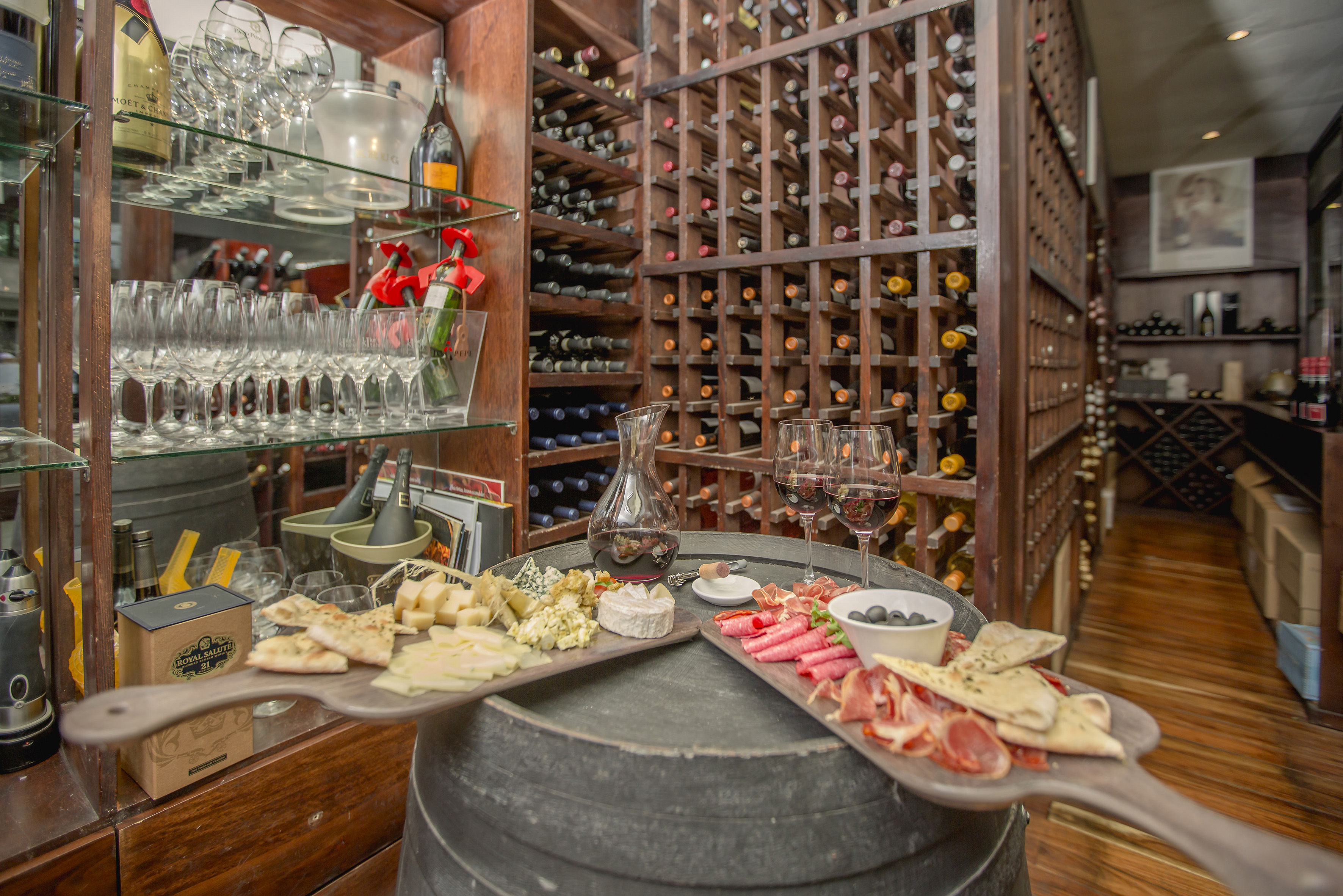 a wine rack with wine glasses and food on a table