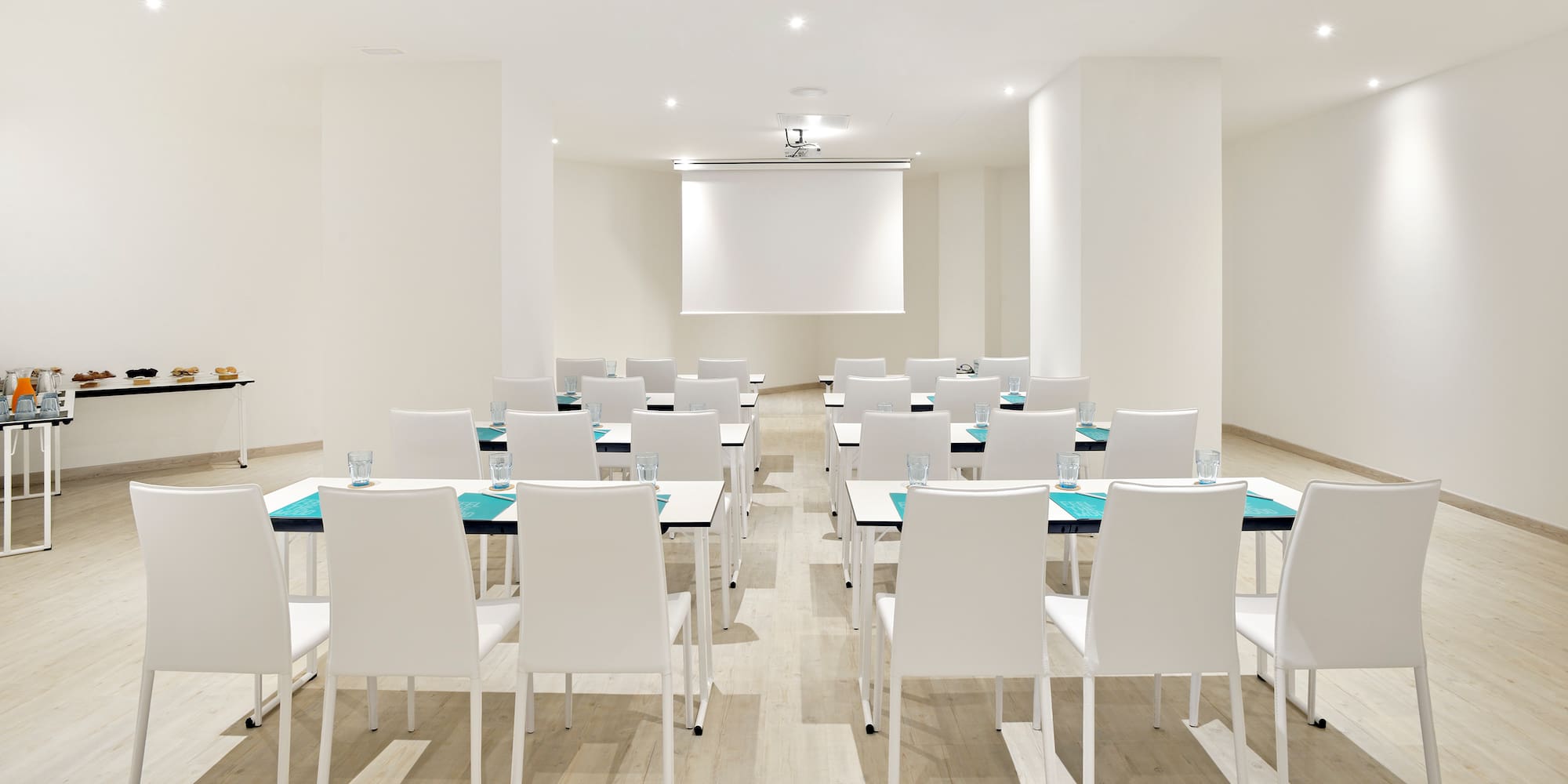 a room with white chairs and tables