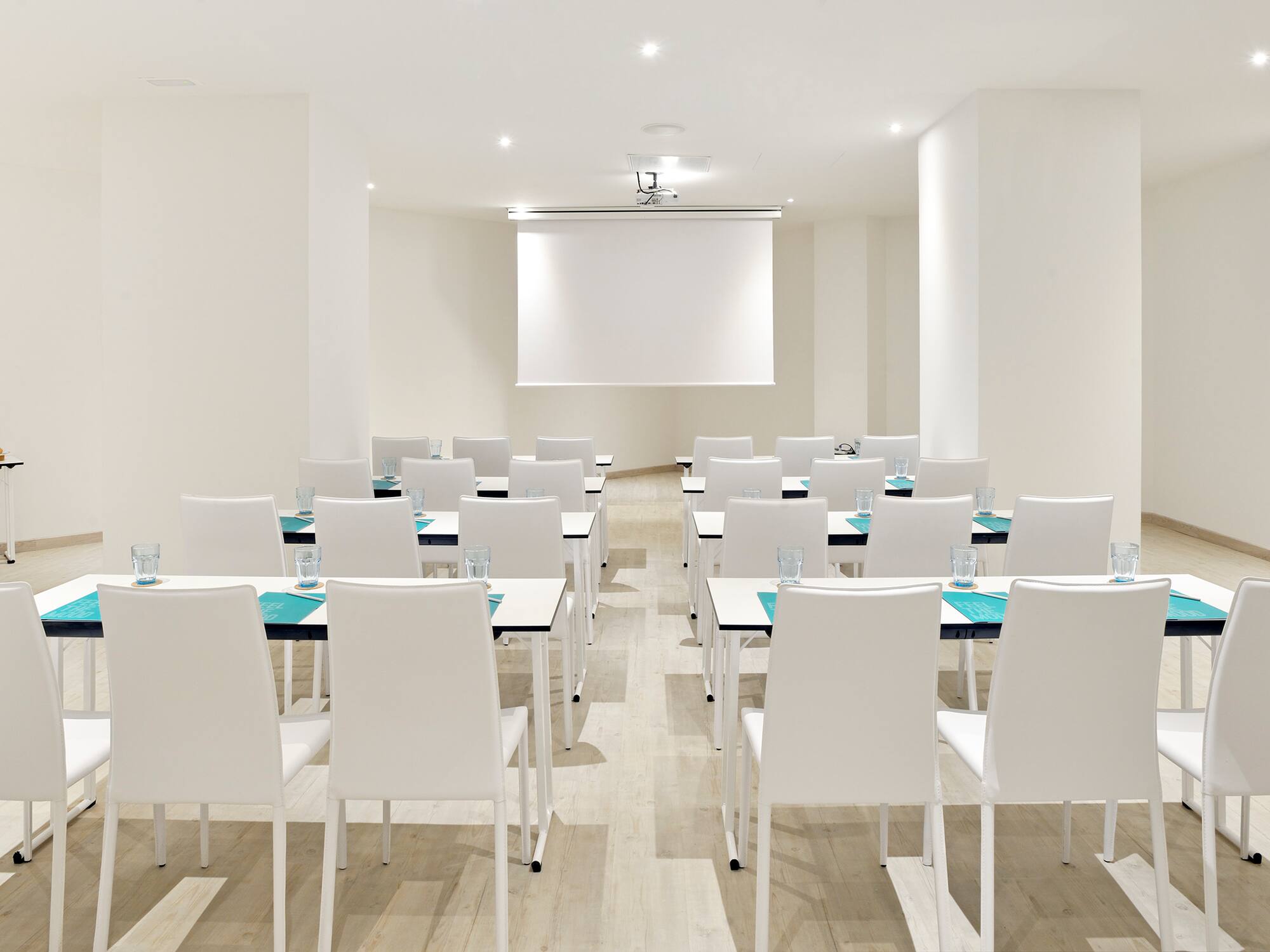 a room with white chairs and tables