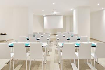 a room with white chairs and tables