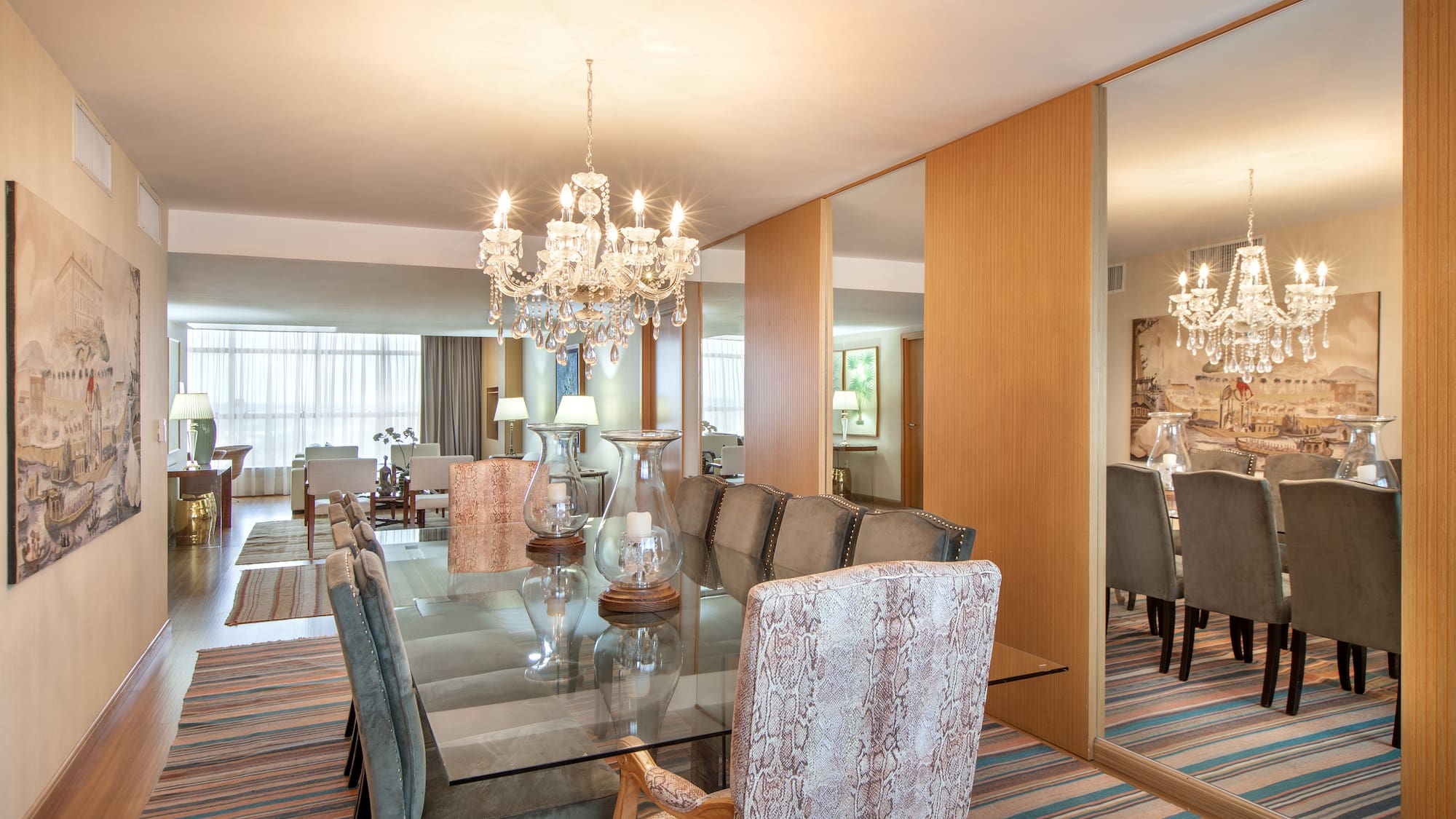 a dining room with a chandelier and a glass table