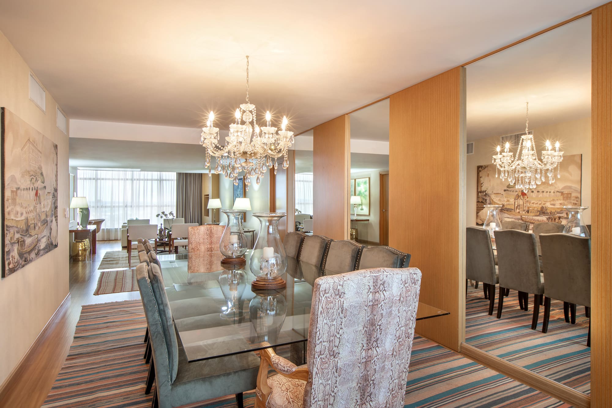 a dining room with a chandelier and a glass table
