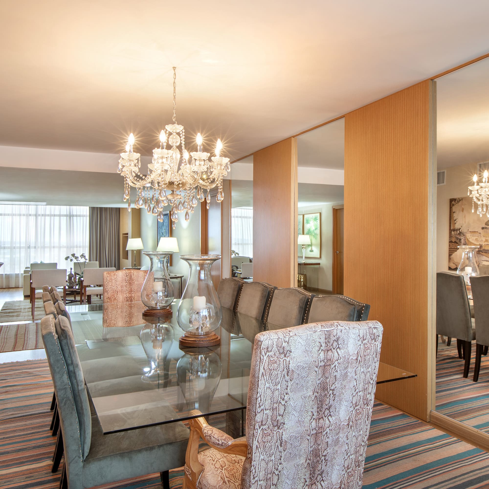 a dining room with a chandelier and a glass table