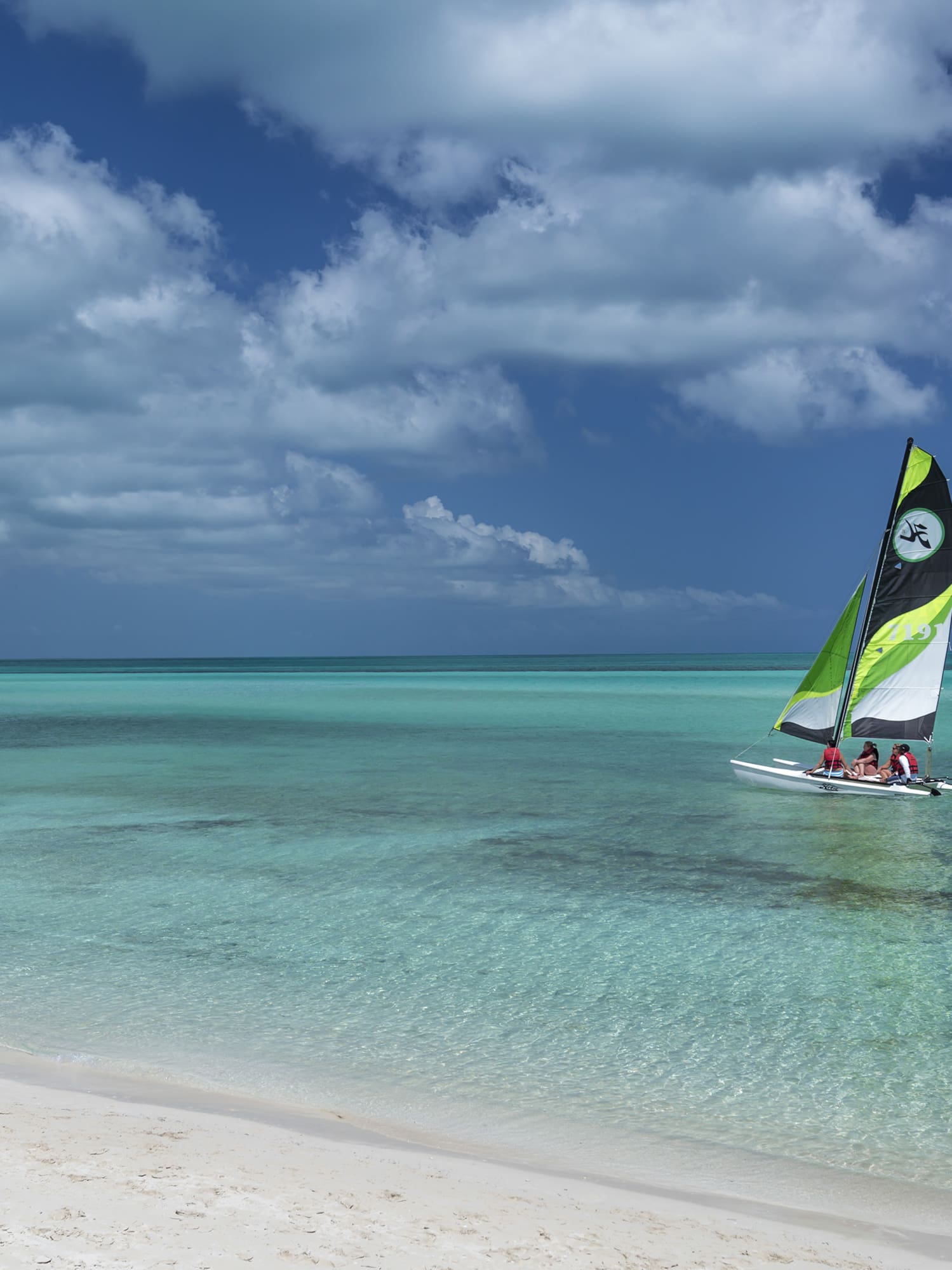 a group of people sailing in a boat on a beach