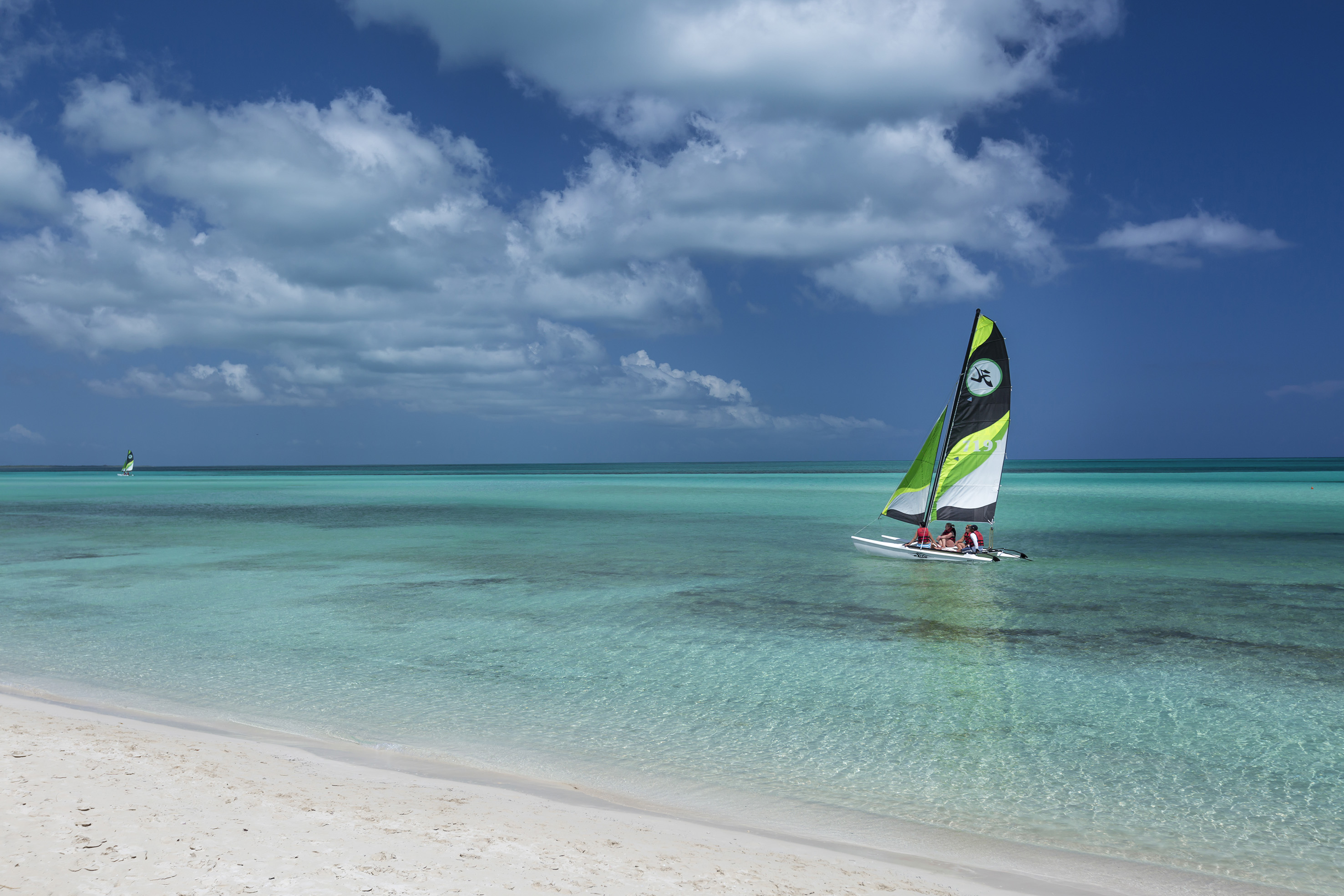 a group of people sailing in a boat on a beach