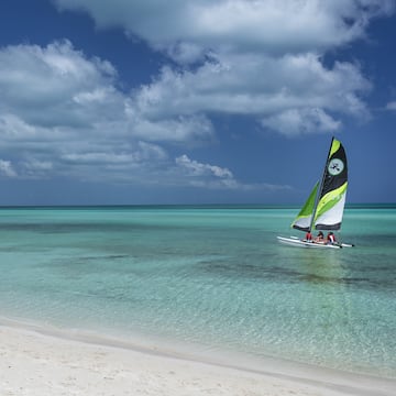 a group of people sailing in a boat on a beach