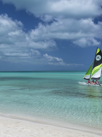a group of people sailing in a boat on a beach