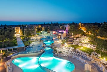 a pool with chairs and a building in the background