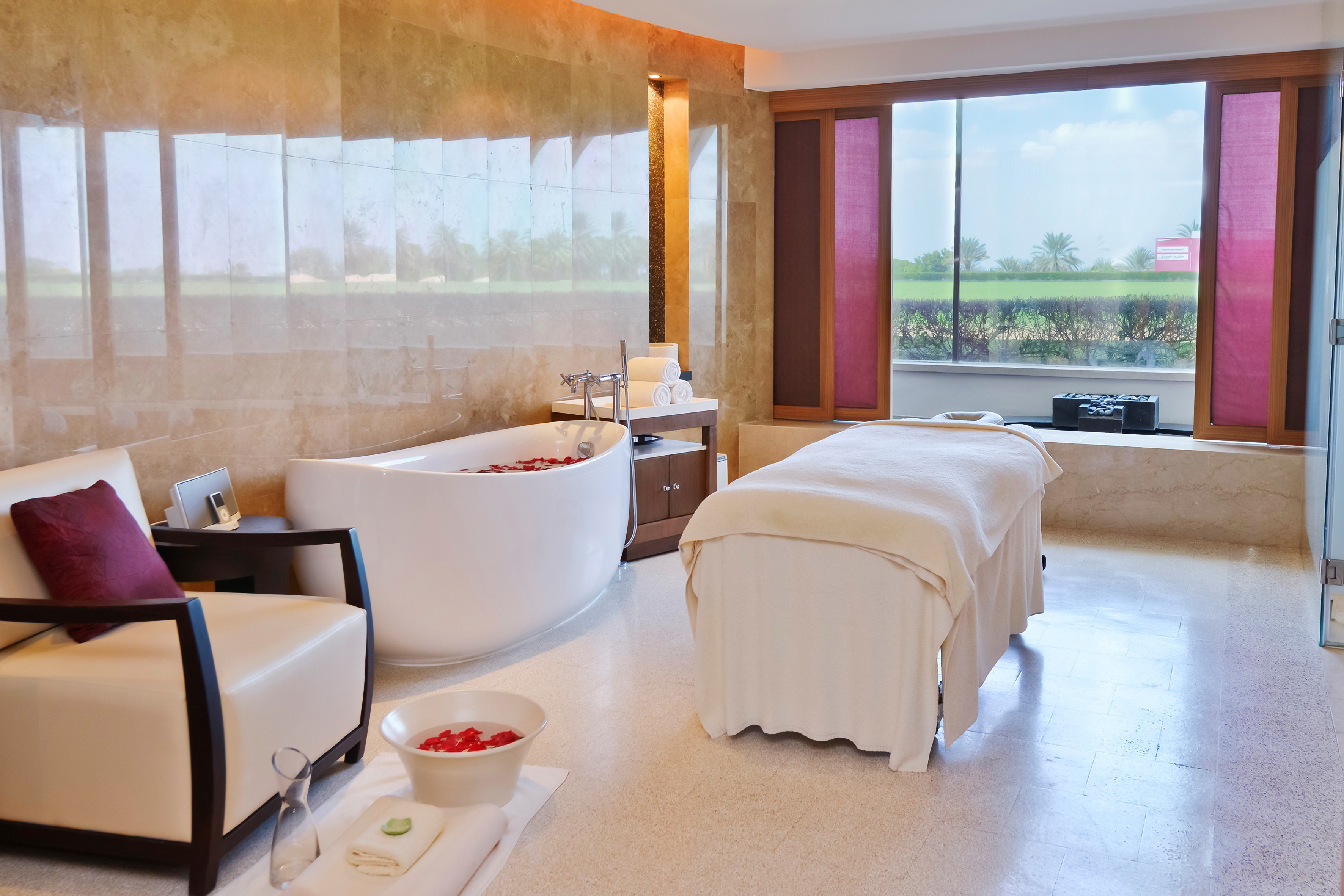 a room with a bathtub and chairs