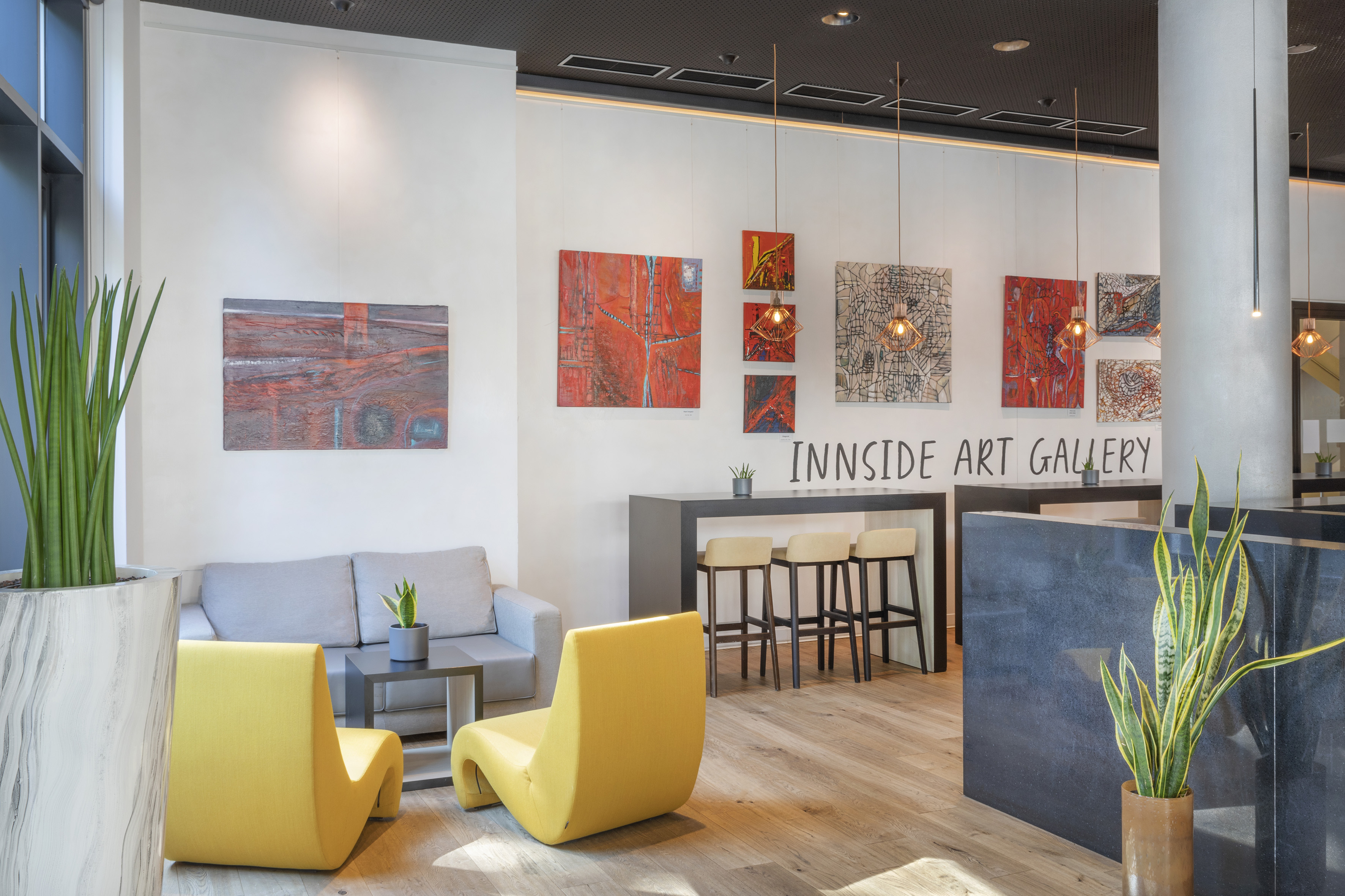 Innside Art Gallery with abstract paintings, modern seating, and bar area.