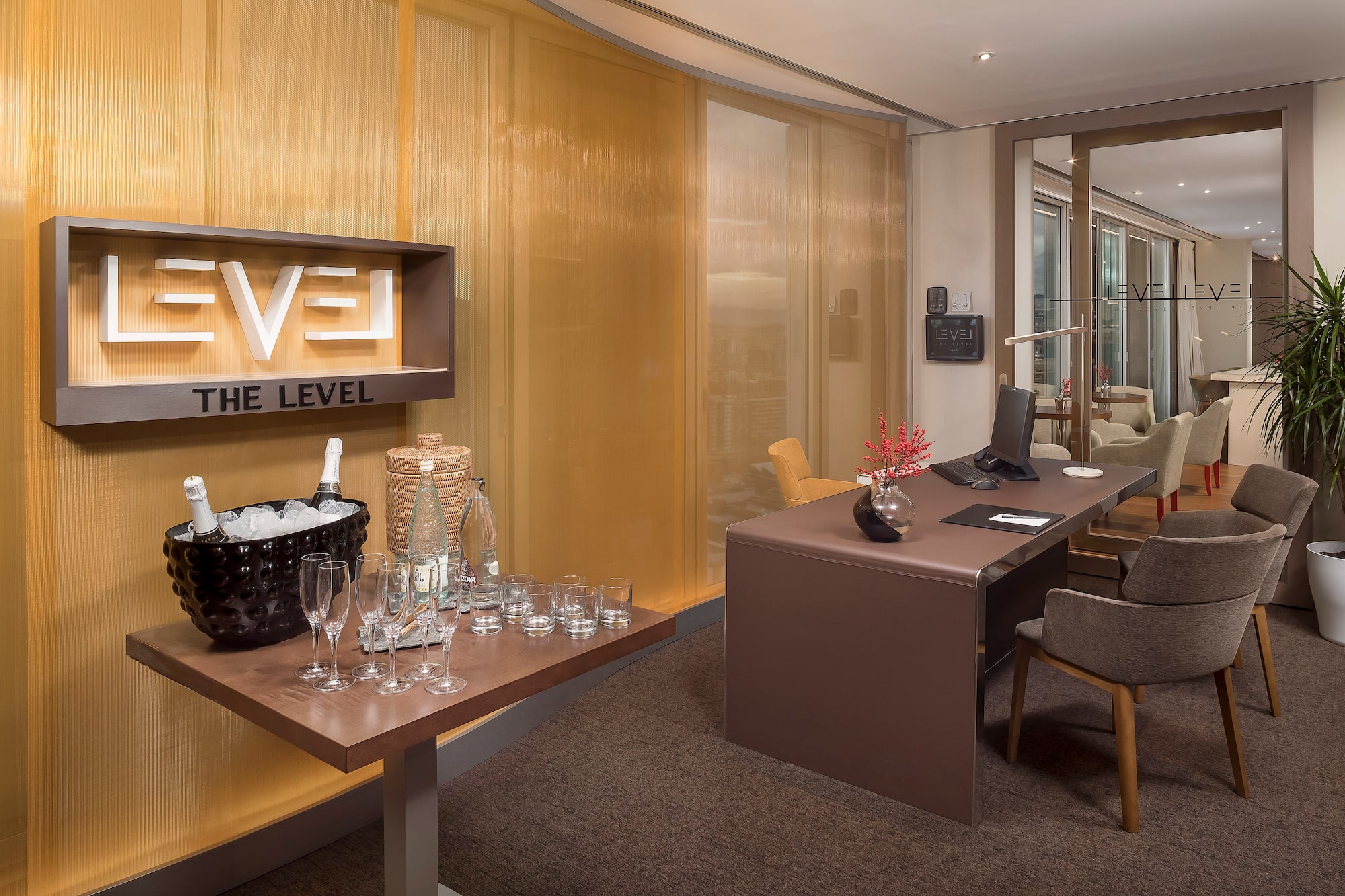 Elegant "THE LEVEL" hotel lounge with champagne service and modern executive desk.