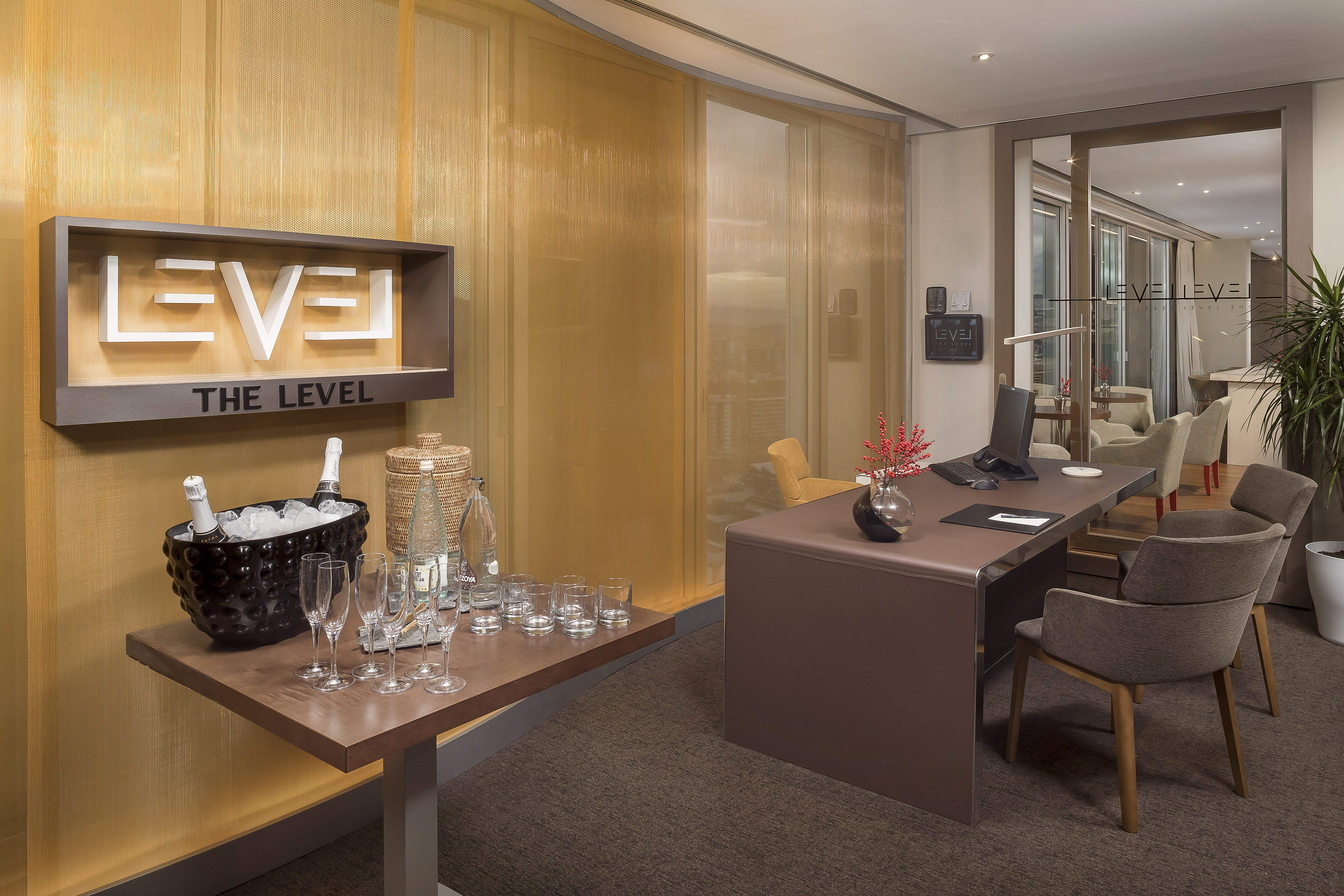 Elegant "THE LEVEL" hotel lounge with champagne service and modern executive desk.