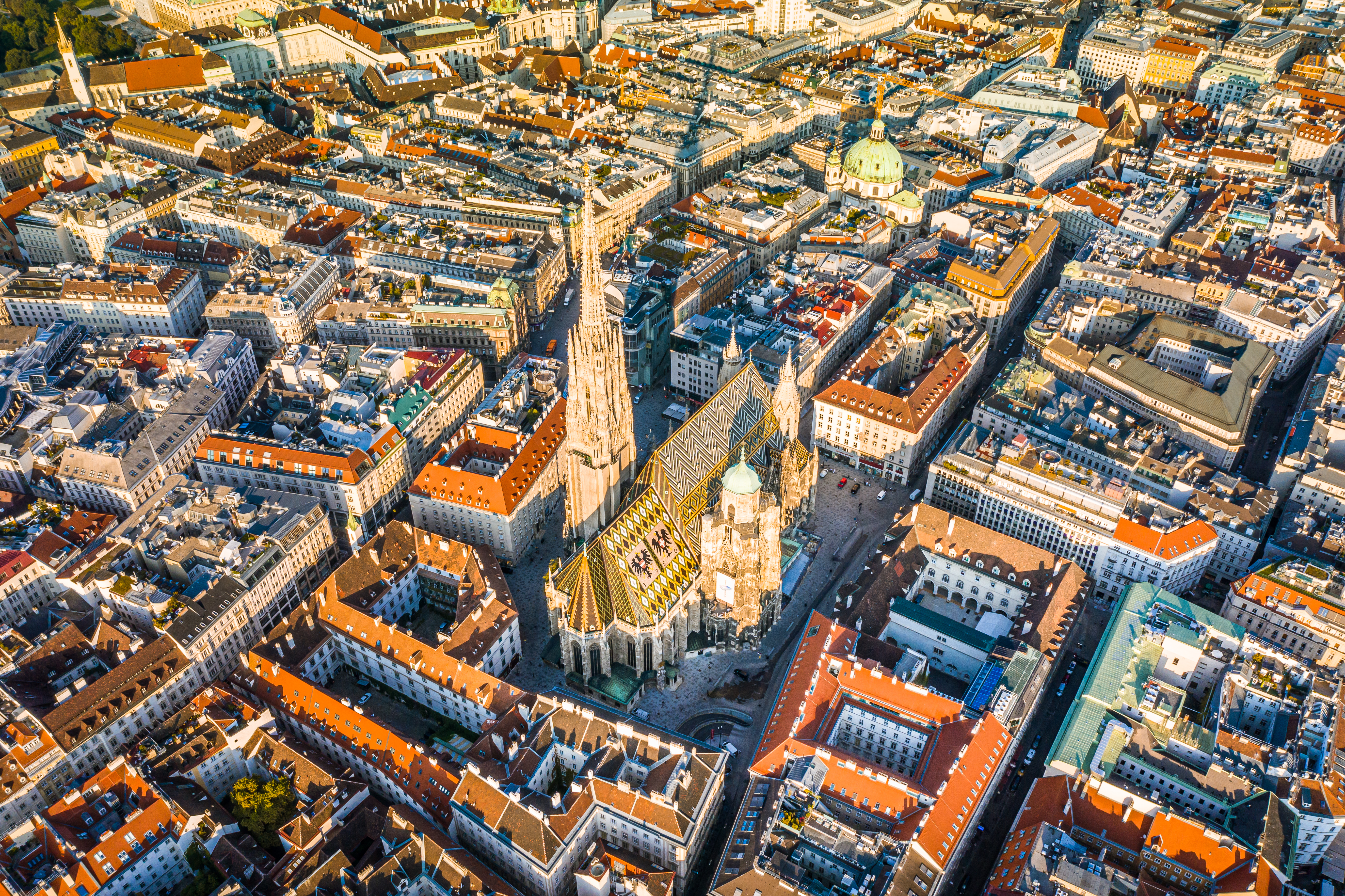 Aerial view: Stephansdom Cathedral, historic Vienna cityscape at sunset.