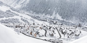 a snowy mountain with houses and trees