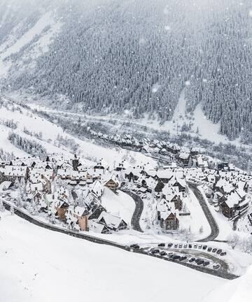 a snowy mountain with houses and trees