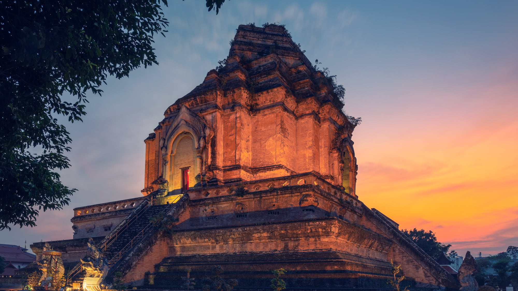 a large stone building with stairs and trees
